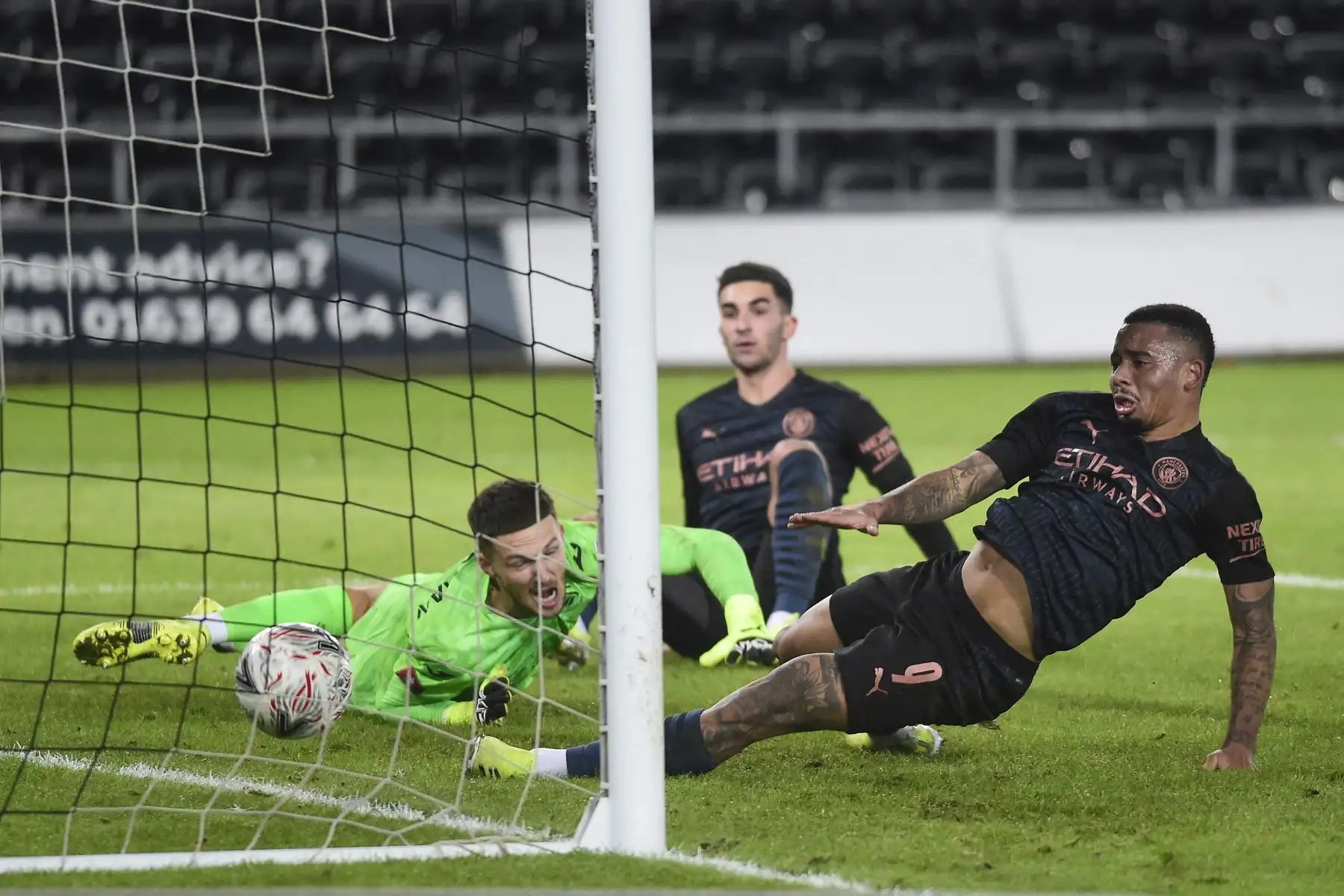 El portero inglés del Swansea City Freddie Woodman y el delantero brasileño del Manchester City Gabriel Jesus observan el balón cruzar la línea de meta mientras su compañero Kyle Walker marca el primer gol de su equipo durante la quinta ronda de la Copa FA inglesa. Foto: AFP