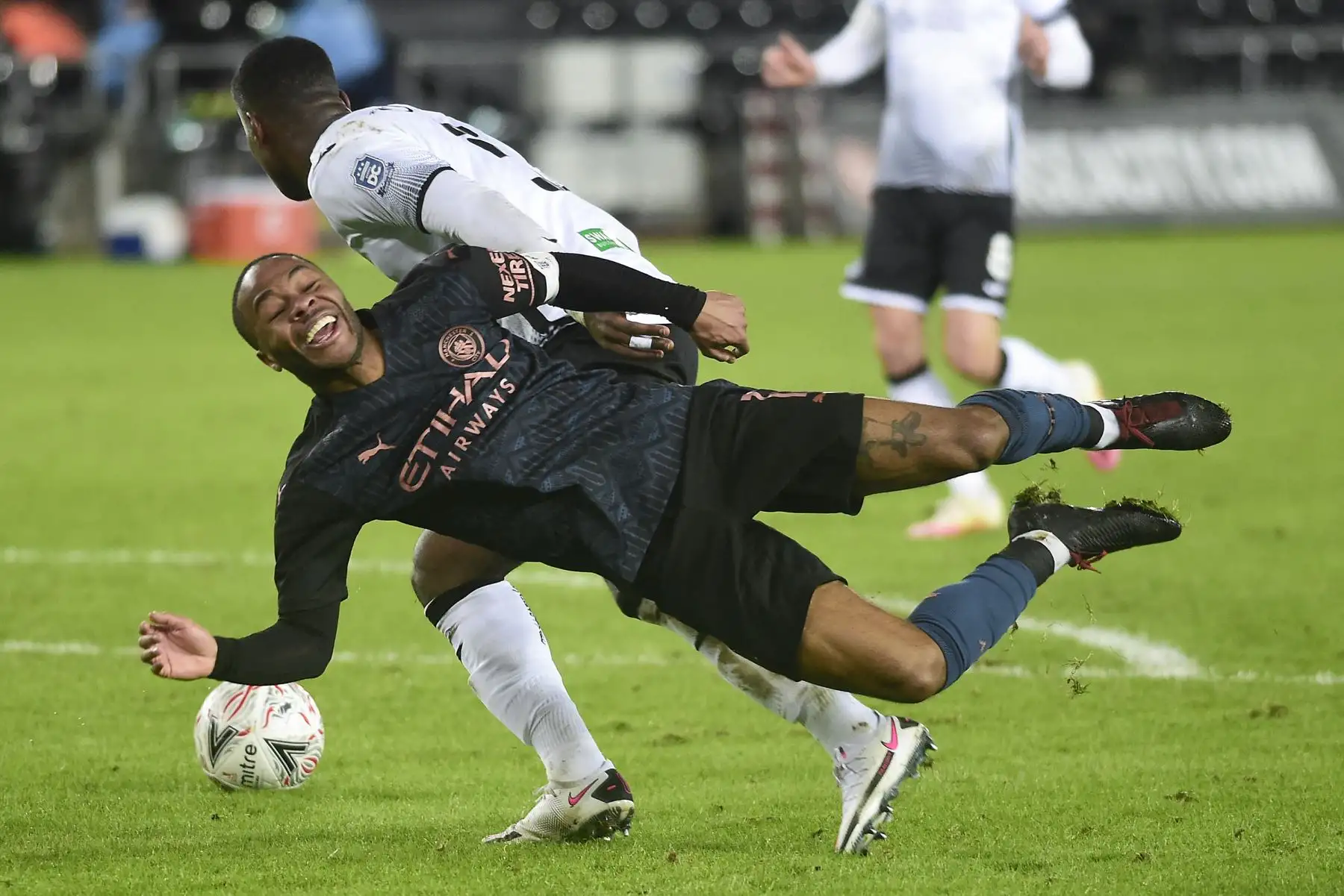 El defensor inglés del Swansea City Marc Guehi compite con el mediocampista inglés del Manchester City Raheem Sterling durante el partido de fútbol de la quinta ronda de la Copa FA inglesa. Foto: AFP