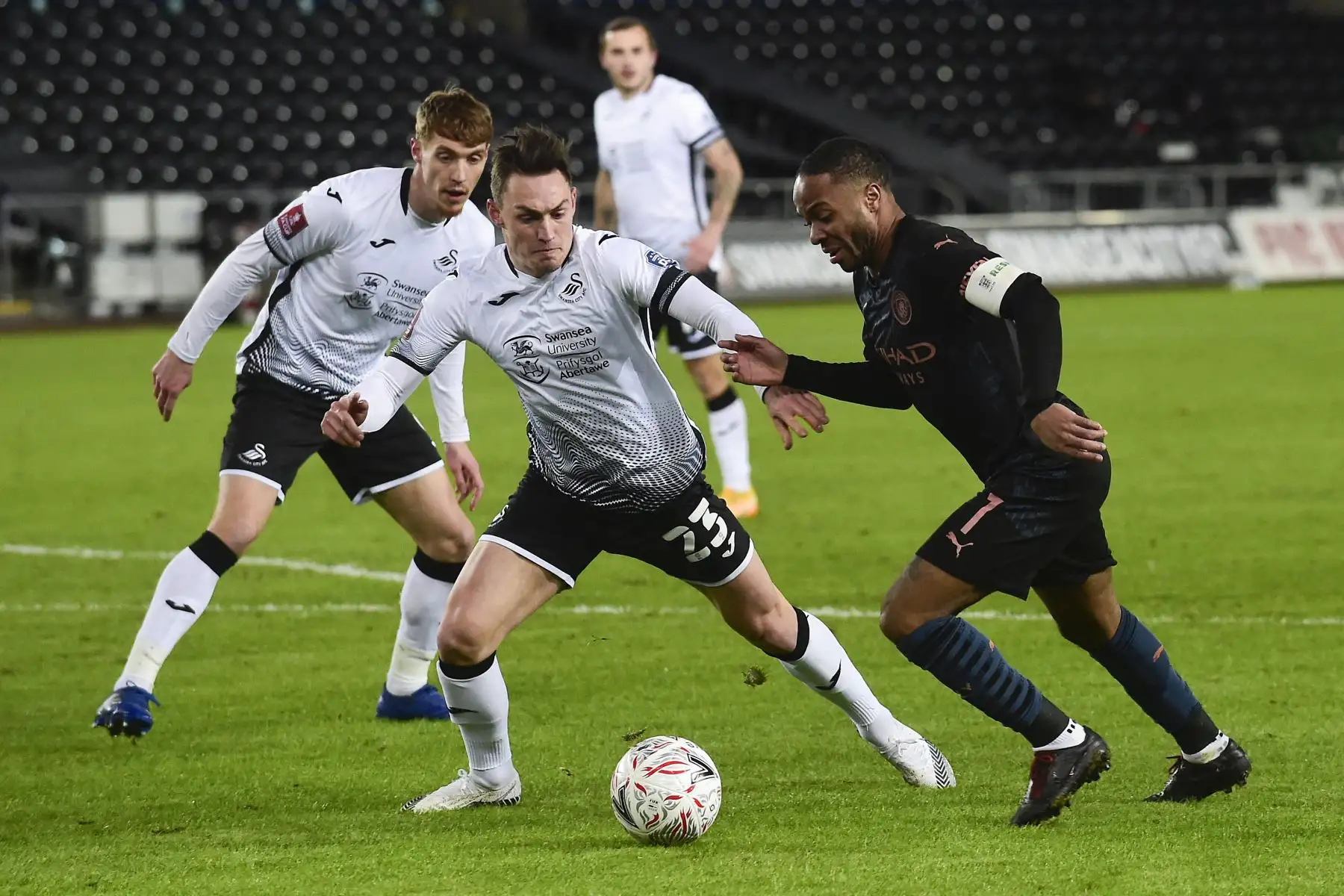 El centrocampista inglés del Manchester City, Raheem Sterling, compite con el defensor galés del Swansea City Connor Roberts durante el partido de fútbol por la quinta ronda de la Copa FA inglesa. Foto: AFP