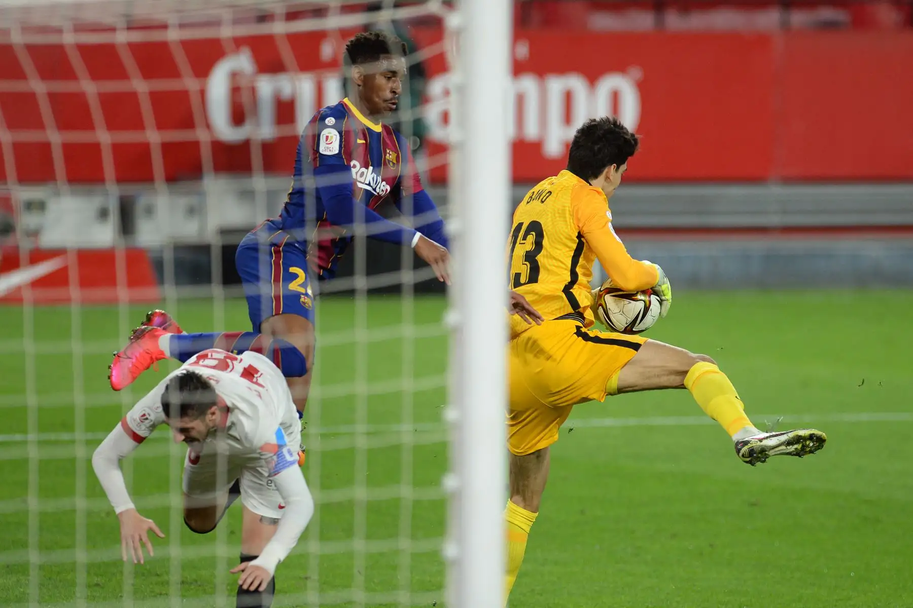 El portero marroquí del Sevilla Bono detiene un disparo a portería del defensor español del Barcelona Junior Firpo durante la Copa del Rey española. Foto: AFP
