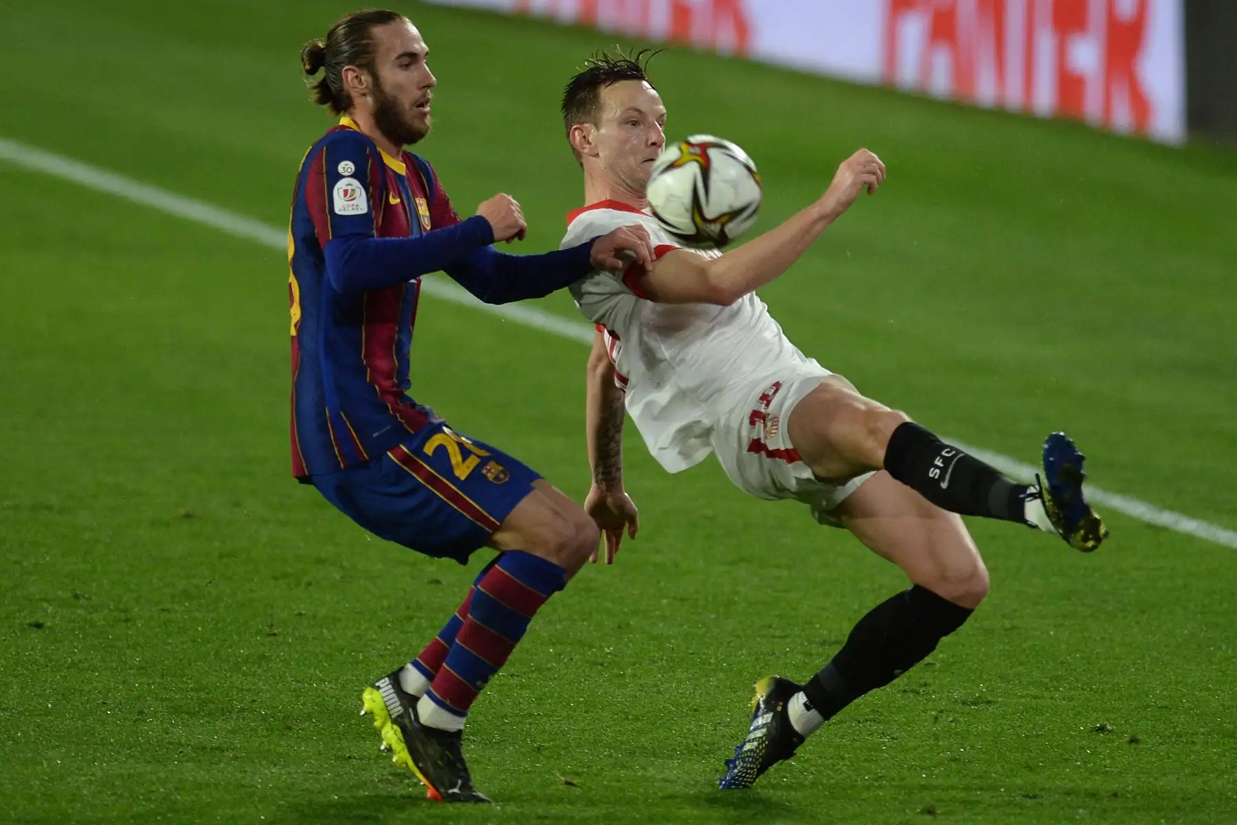 El defensor español del Barcelona Oscar Mingueza desafía al centrocampista croata del Sevilla Ivan Rakitic durante la semifinal de la Copa del Rey de Españ. Foto: AFP