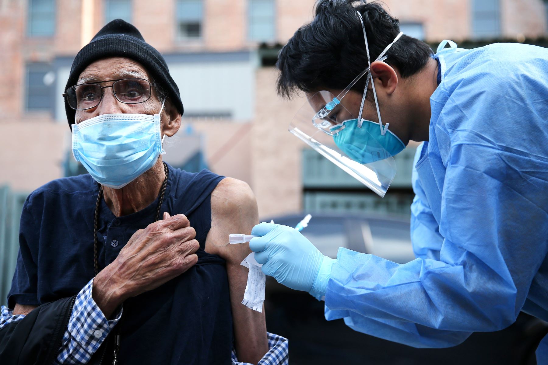 Eduardo Chavira recibe una tirita después de que un trabajador de la salud le administrara una dosis de la vacuna Moderna COVID-19 fuera de la Misión de Los Ángeles ubicada en la comunidad de Skid Row, en Estados Unidos. Foto: AFP