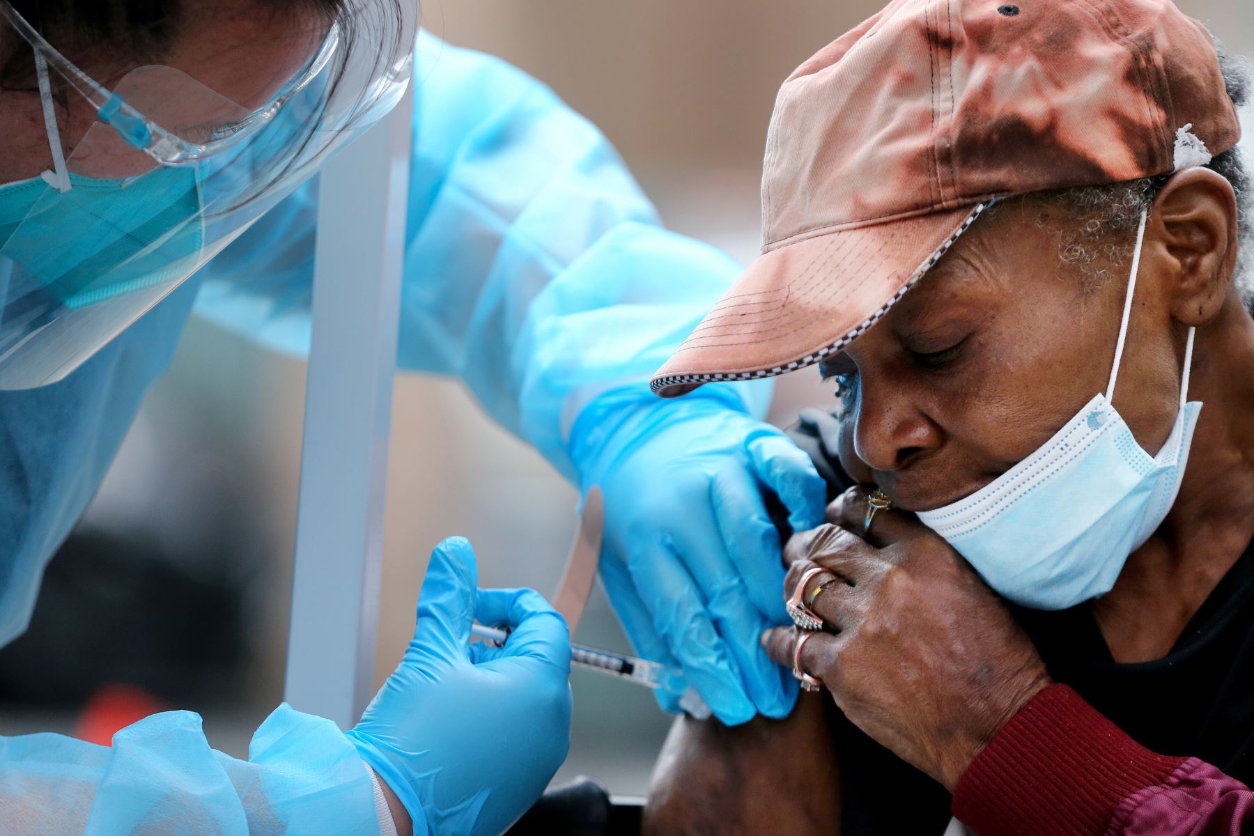 Viola, de 75 años, recibe una dosis de la vacuna Moderna COVID-19 de un trabajador de la salud fuera de la Misión de Los Ángeles ubicada en la comunidad de Skid Row, en Estados Unidos. Foto: AFP