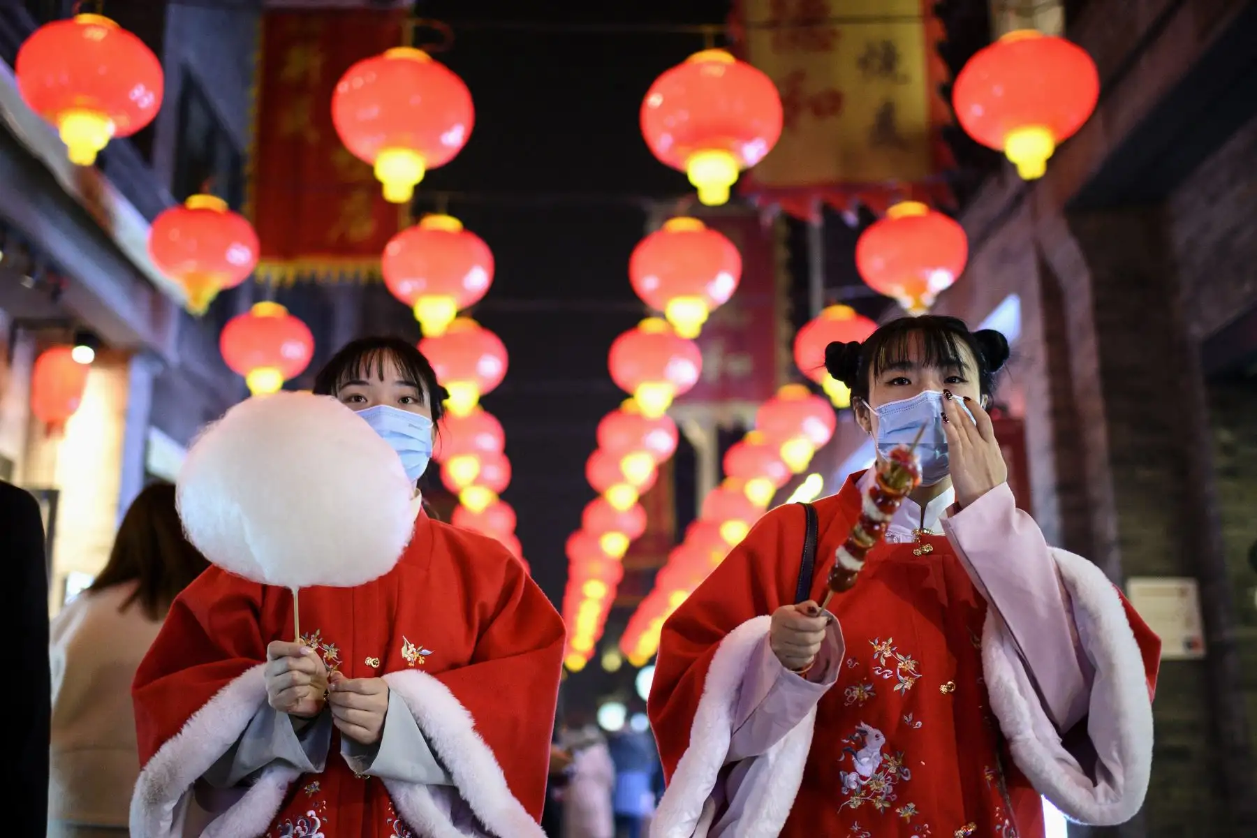 Personas con máscaras caminan por la calle Qianmen en Beijing el 11 de febrero de 2021, antes del Año Nuevo Lunar, que marca el comienzo del Año del Buey el 12 de febrero. Foto: AFP