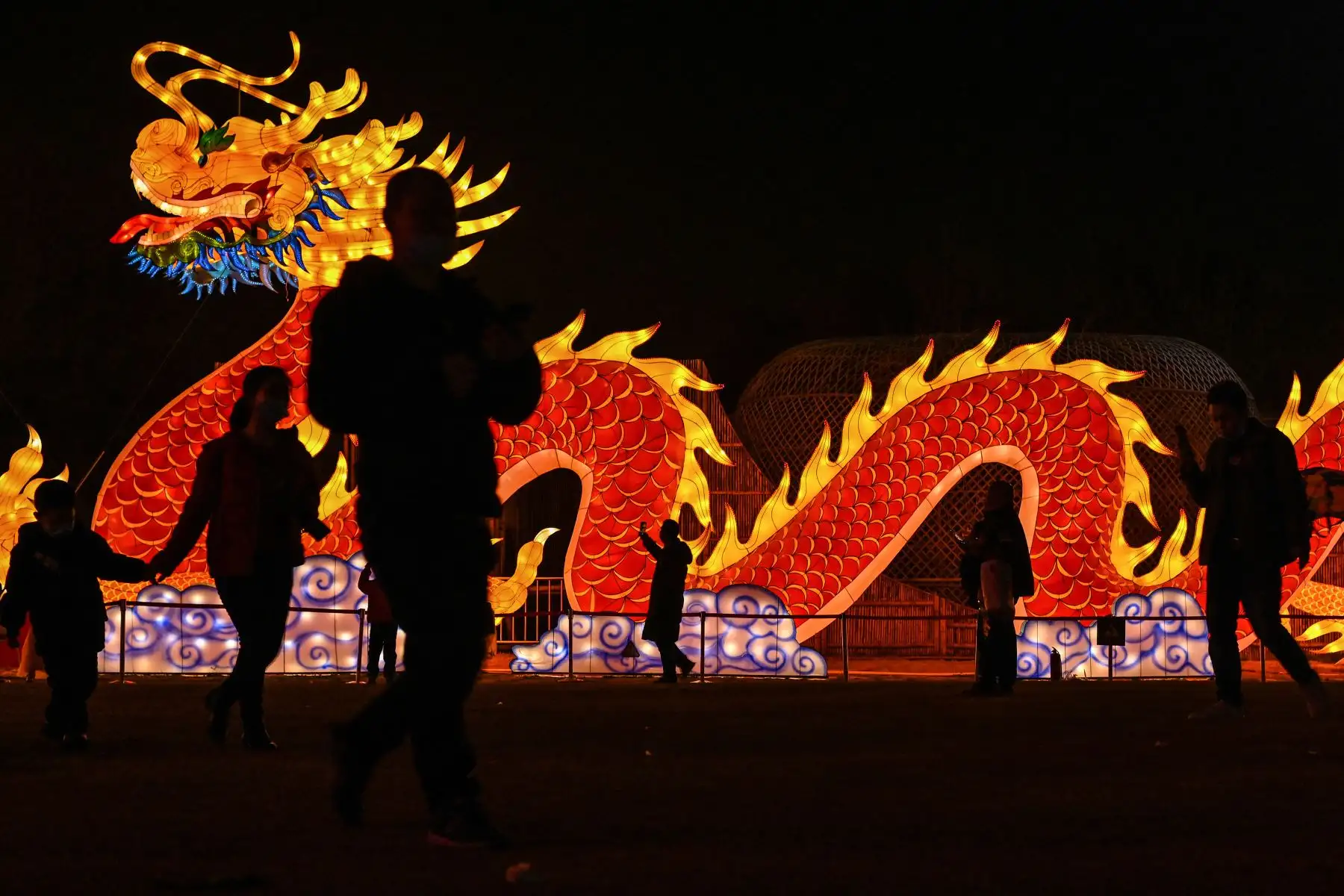La gente transita junto a una linterna de dragón gigante en un parque en Wuhan en la provincia central de Hubei en China el 11 de febrero de 2021, antes del inicio del Año Nuevo Lunar. Foto: AFP