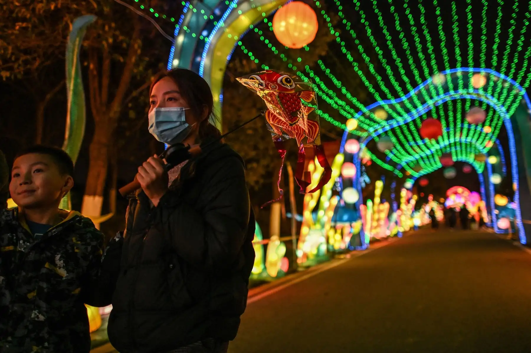 La gente pasa junto a los faroles de un parque en Wuhan, en la provincia central de Hubei, en China, el 11 de febrero de 2021, antes del inicio del Año Nuevo Lunar. Foto: AFP