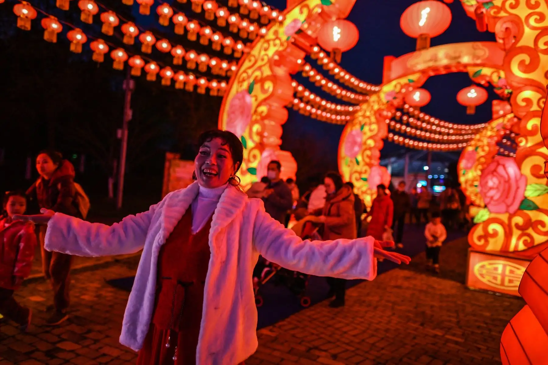 Una mujer baila mientras graba un video en su teléfono móvil junto a linternas en un parque en Wuhan en la provincia central de Hubei en China el 11 de febrero de 2021, antes del inicio del Año Nuevo Lunar. Foto: AFP