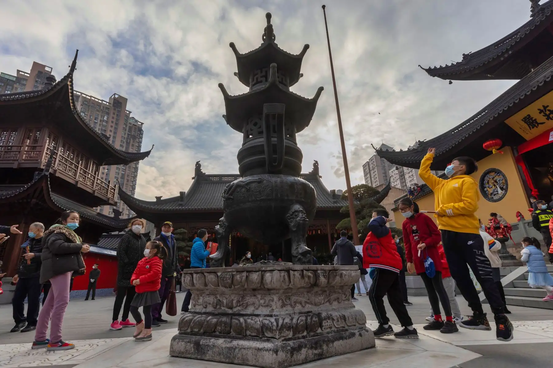 La gente lanza monedas en el Templo del Buda de Jade en Shanghai, China, 12 de febrero de 2021. Foto: EFE