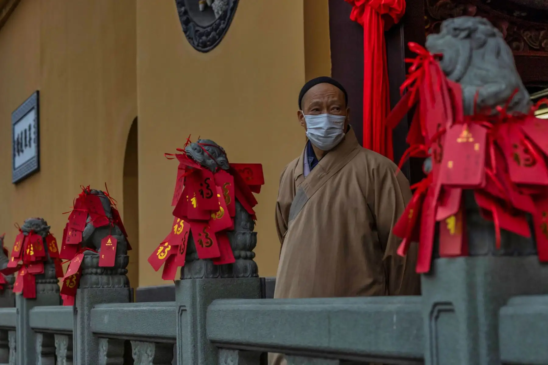 Un monje budista luce junto a las oraciones escritas que dejaron los visitantes en el Templo del Buda de Jade en Shanghai, China. Foto: EFE