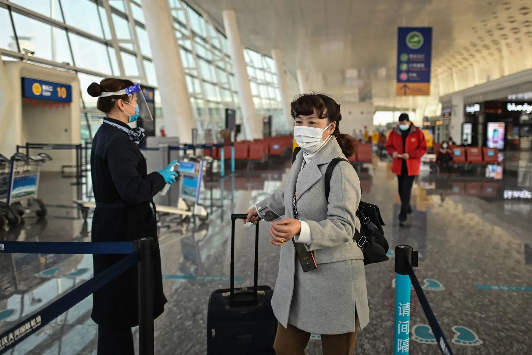 Un pasajero con mascarilla como medida preventiva contra el coronavirus Covid-19 aborda un vuelo a Shanghai en el Aeropuerto Internacional Tianhe en Wuhan, provincia central de Hubei, en China. Foto: AFP