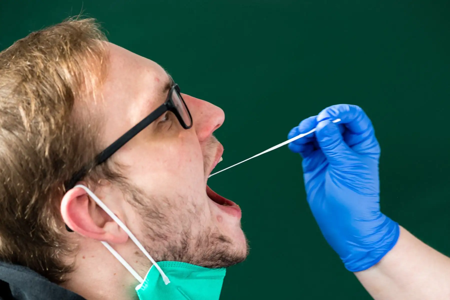 Un personal médico toma una muestra de hisopo de la boca de un hombre para una prueba de antígeno Covid-19, en el hospital universitario de Halle, en el este de Alemania. Foto: AFP