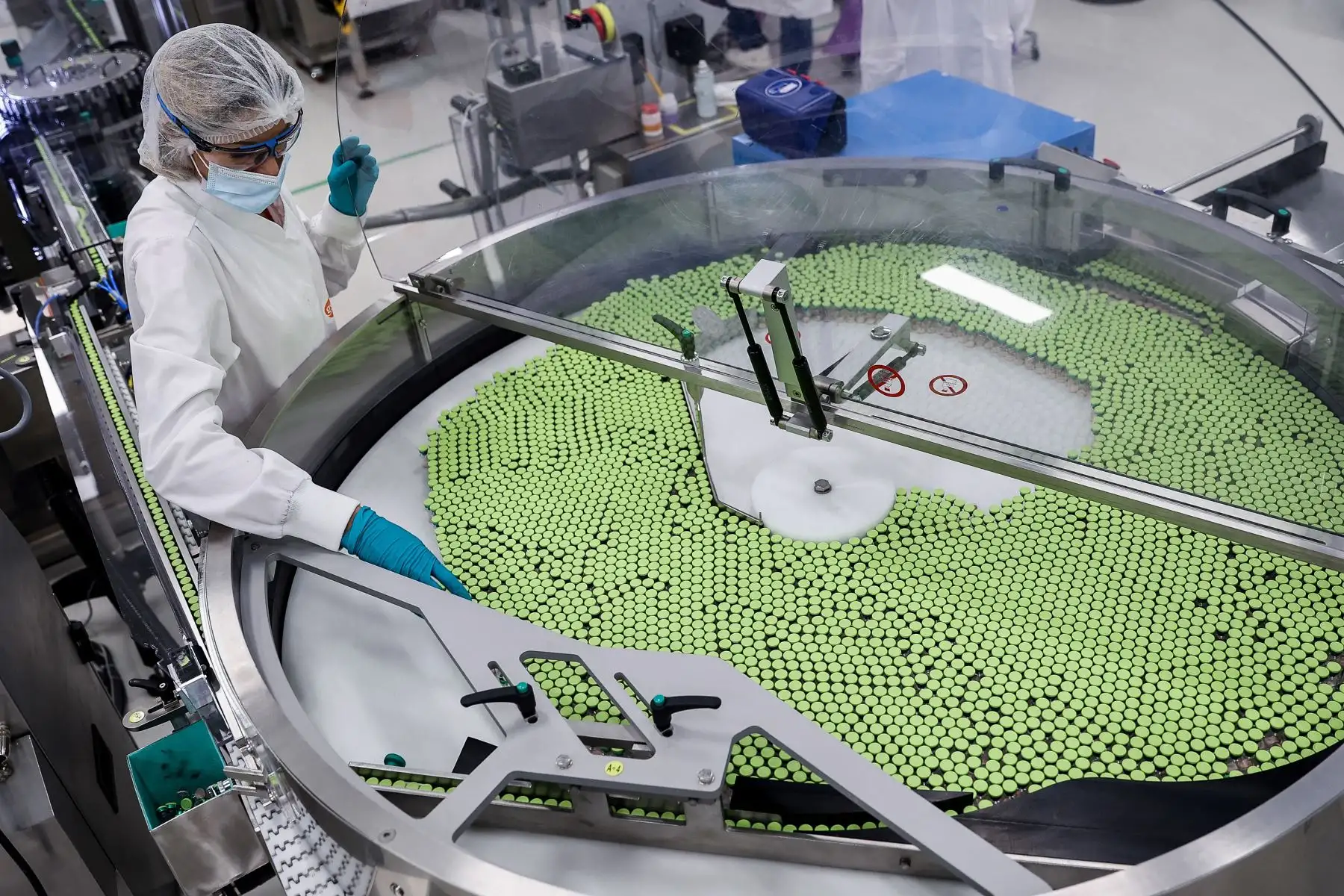 Un empleado está trabajando en la línea de empaque de vacunas de la fábrica de la compañía farmacéutica británica GlaxoSmithKline (GSK) en Wavre el 8 de febrero de 2021, donde se producirá la vacuna Covid-19 CureVac, en Bélgica. Foto: AFP