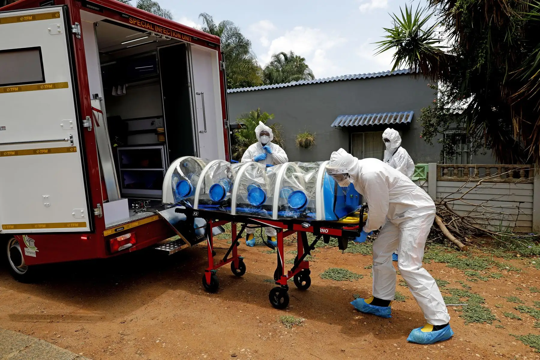 Un paramédico de la Unidad Especial de Infecciones de la Ciudad de Tshwane descarga la cámara de aislamiento equipada con un sistema de filtración de presión negativa para atender a un posible paciente positivo de COVID-19 en su casa, ubicada en el norte de Pretoria, Sudáfrica, el 15 de enero 2021. Foto: AFP