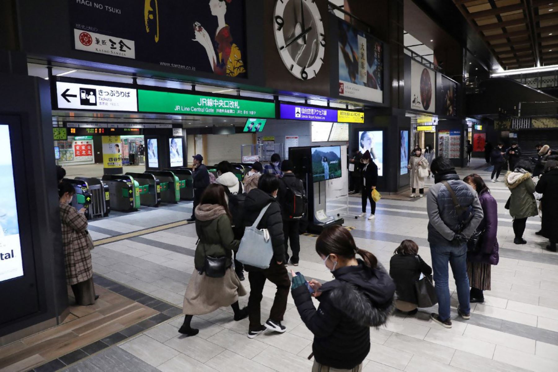 Las personas se paran frente a las puertas de entrada en la estación JR Sendai en Sendai, después de que un fuerte terremoto de magnitud 7.1 sacudiera la costa este de Japón. Foto: AFP