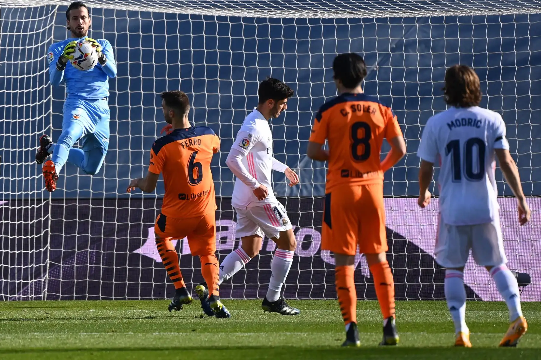 El portero español del Valencia Jaume Domenech, detiene un disparo a puerta del centrocampista español del Real Madrid Marco Asensio, durante el partido de fútbol de la liga española entre el Real Madrid y el Valencia. 
Foto: AFP