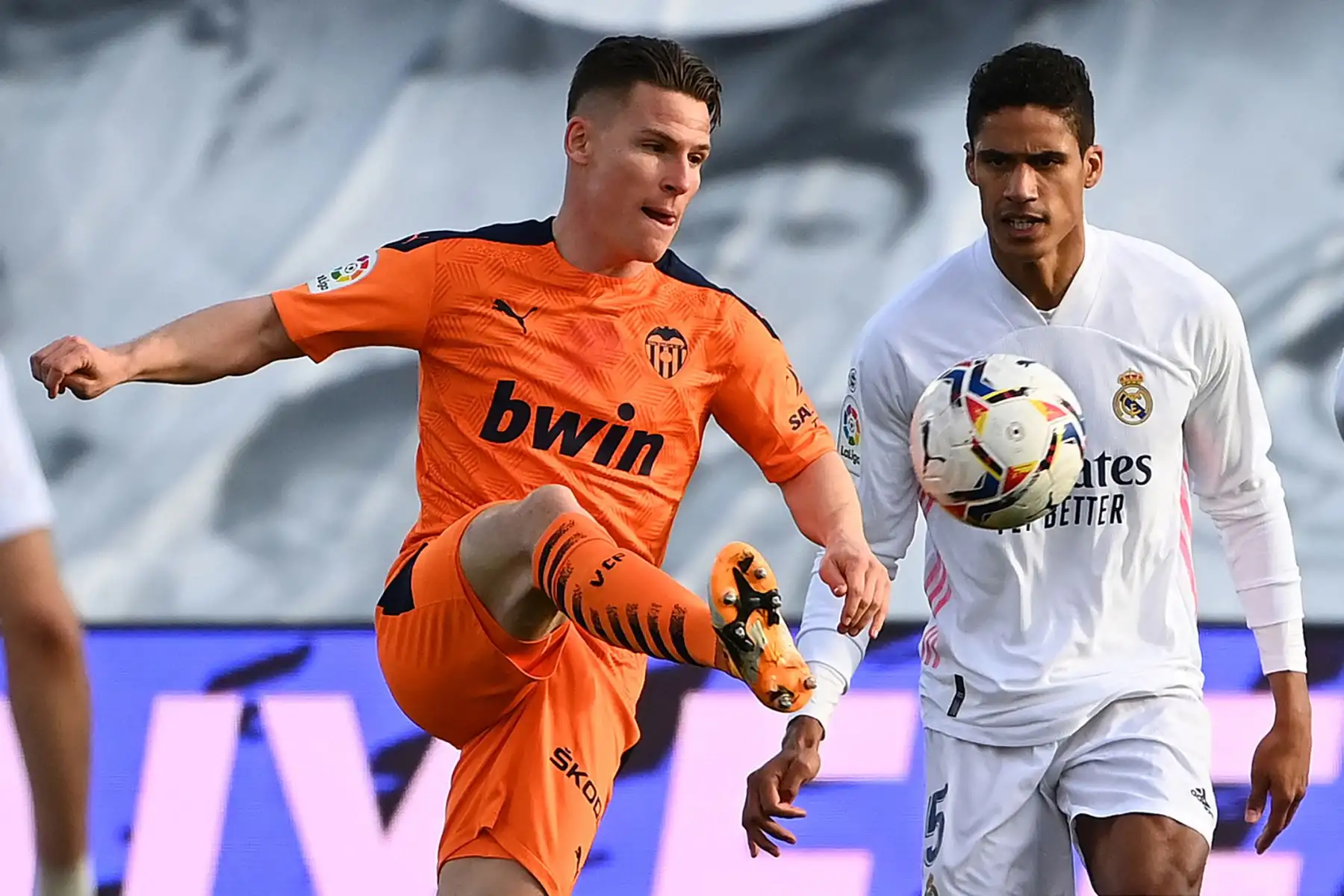 El delantero francés del Valencia Kevin Gameiro desafía al defensor francés del Real Madrid Raphael Varane, durante el partido de fútbol de la liga española entre el Real Madrid y el Valencia.
Foto: AFP