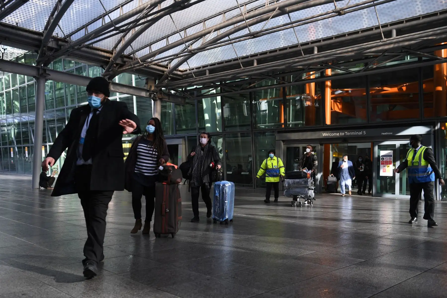 Los pasajeros son acompañados a un autobús en el aeropuerto de Heathrow para ser llevados a un hotel en cuarentena obligatoria en el oeste de Londres. Foto: AFP
