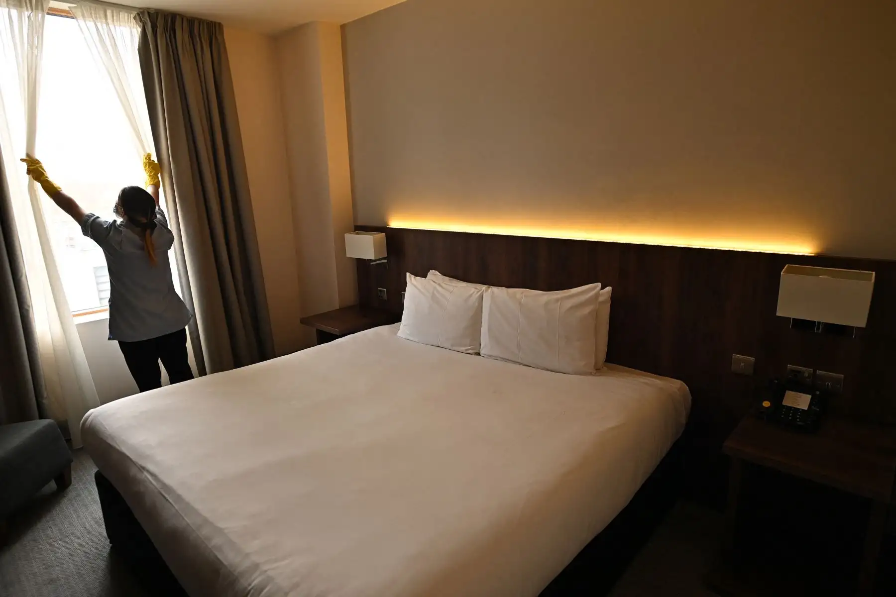 Un miembro del personal de limpieza prepara una habitación para un huésped en el hotel St Giles, cerca del aeropuerto de Heathrow en el oeste de Londres. Foto: AFP