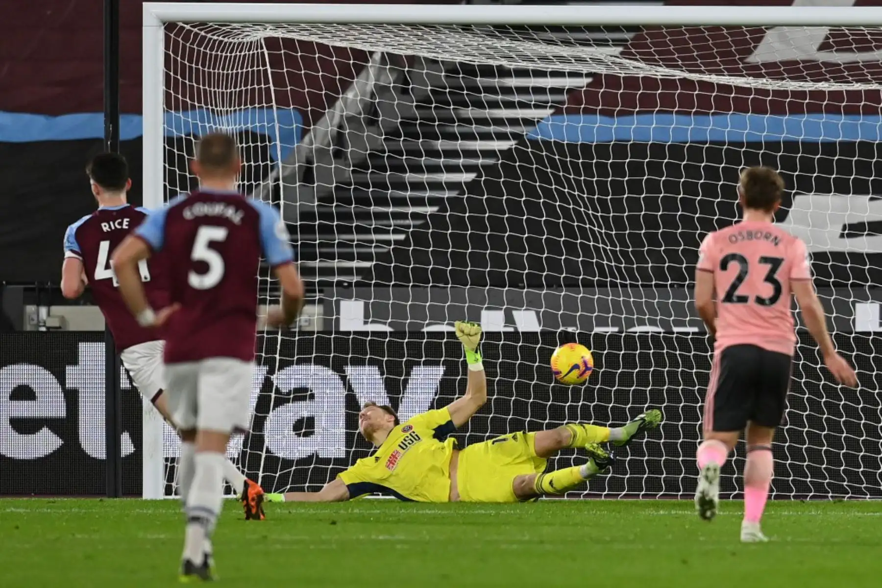 El centrocampista inglés del West Ham United, Declan Rice (L), anota el gol inicial desde el punto de penalti pasando al portero inglés del Sheffield United, Aaron Ramsdale, durante el partido de fútbol de la Premier League inglesa entre el West Ham United y el Sheffield United en el London Stadium.

Foto:AFP