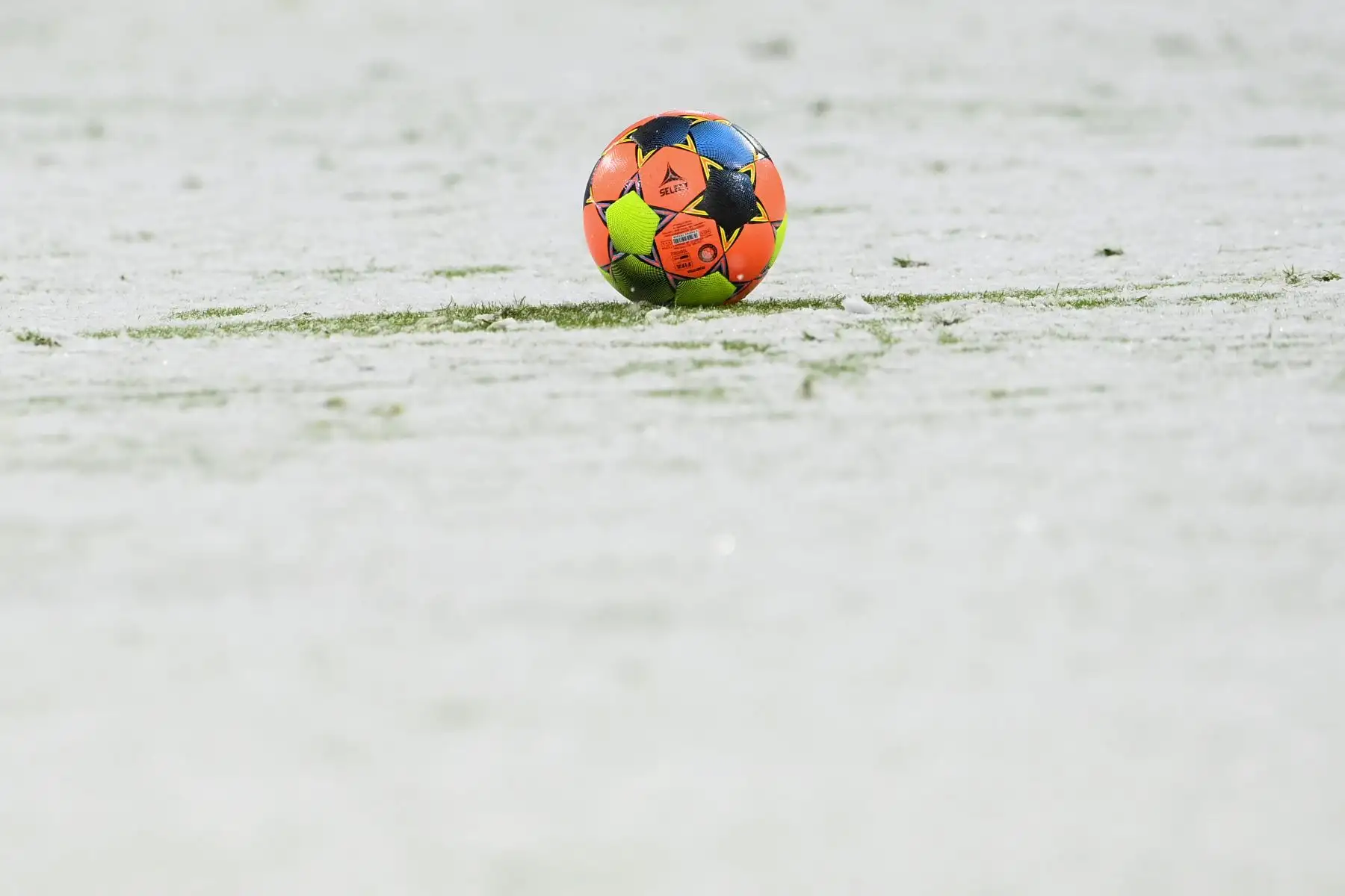 El balón en el campo luce cubierto de nieve durante el partido de fútbol de la Bundesliga de primera división alemana FC Bayern Munich v DSC Armenia Bielefeld en Munich, Alemania. Foto: AFP