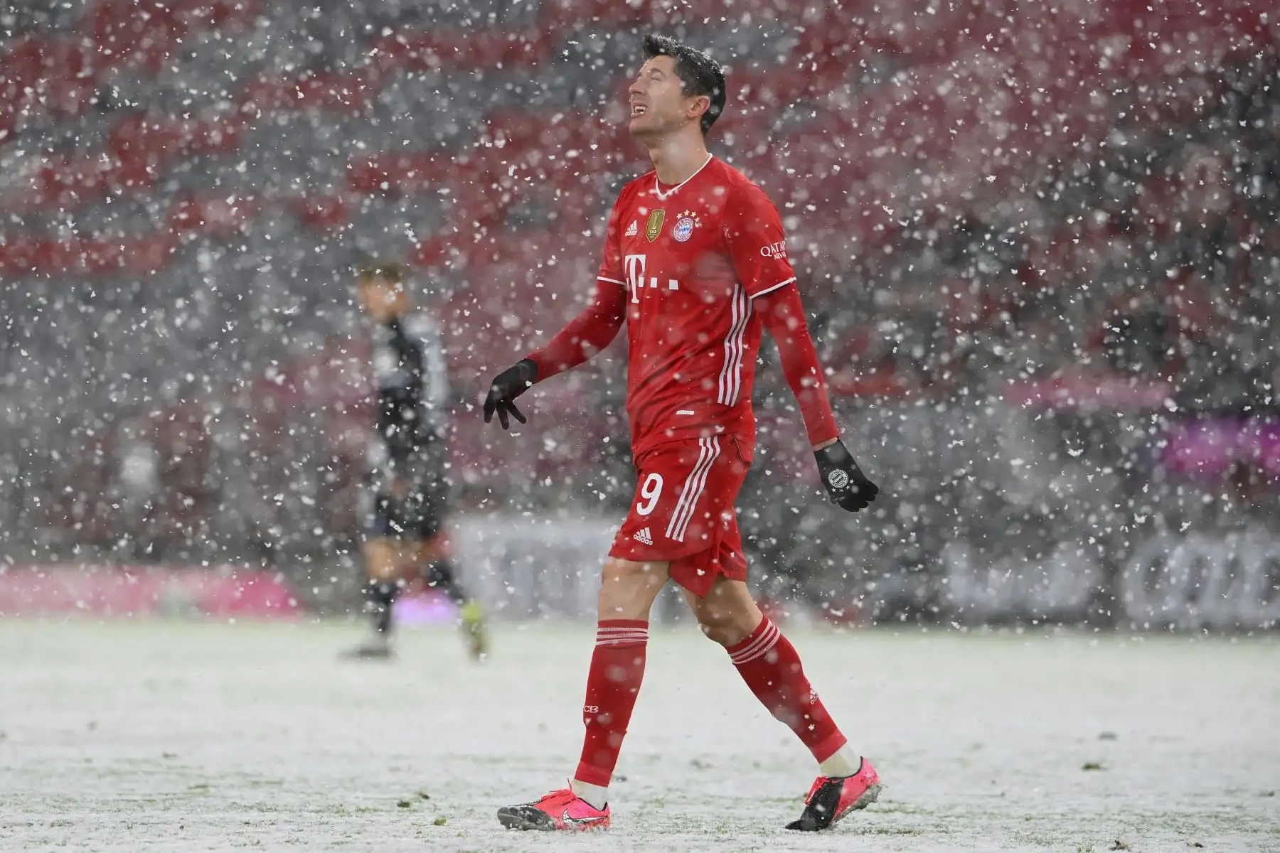 El delantero polaco del Bayern de Múnich, Robert Lewandowski, reacciona cuando cae la nieve durante el partido de fútbol de la Bundesliga. Foto: AFP