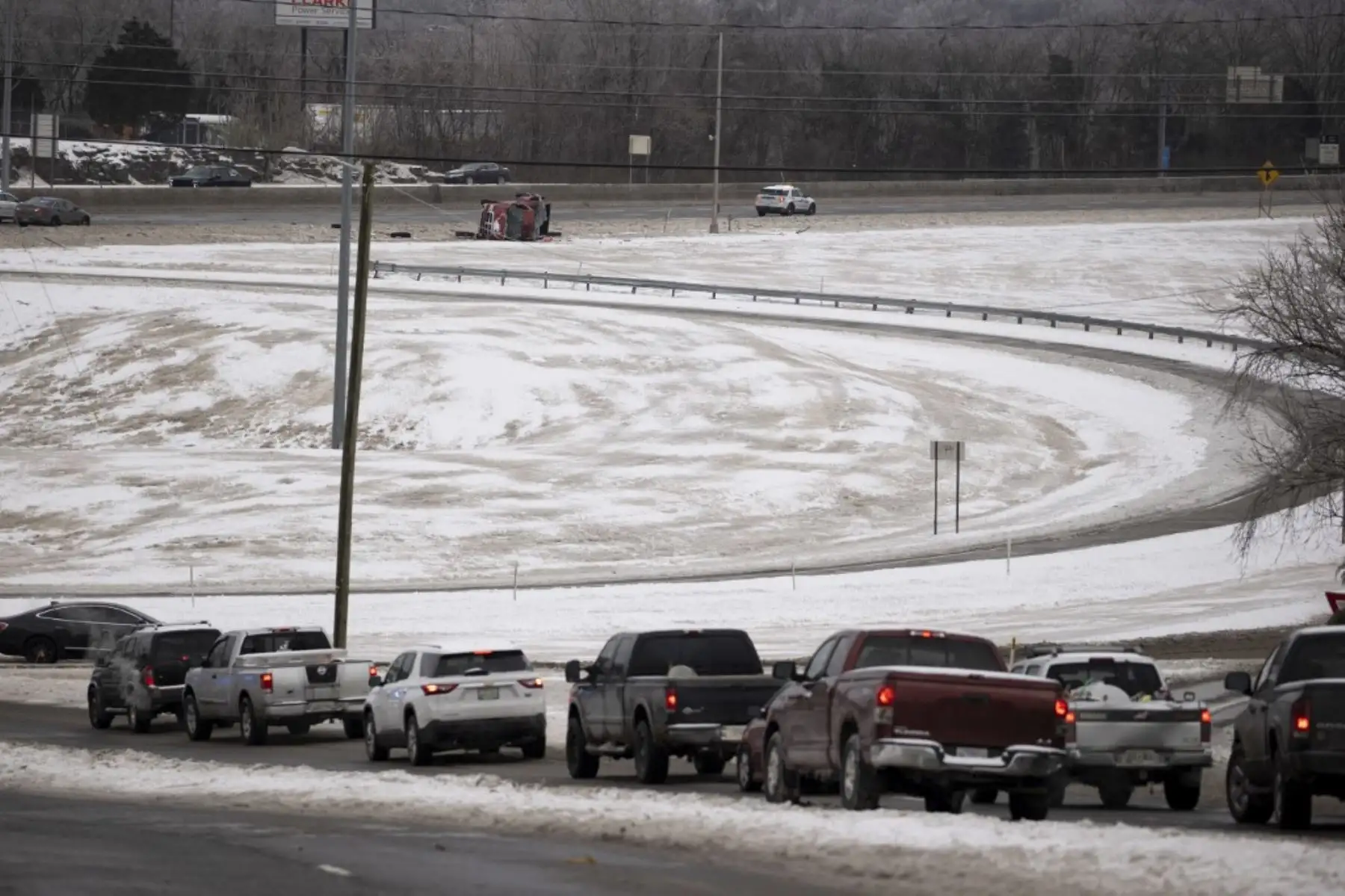 Los vehículos esperan en el tráfico mientras la policía cierra los carriles de tráfico en dirección este de la I-24 debido a un accidente de vehículo por vuelco el 16 de febrero de 2021 en Nashville, Tennessee. Las grandes tormentas invernales se han extendido por 26 estados con una combinación de temperaturas bajo cero y precipitaciones. Foto: AFP