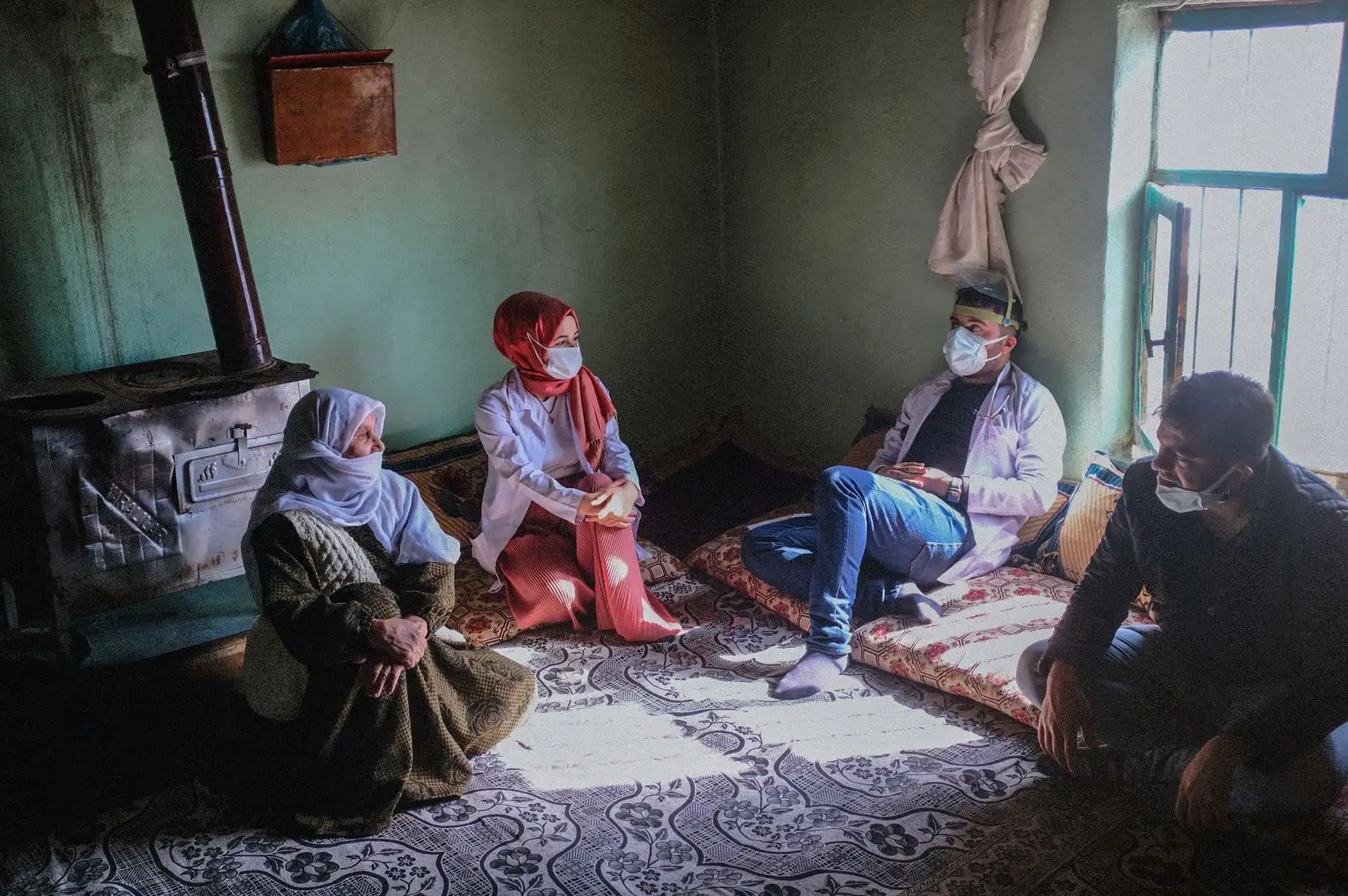 Zeri Saymaz conversa con miembros del equipo de vacunación del hospital público de Bahcesaray después de ser vacunado con la CoronaVac Covid-19 de Sinovac, en la aldea de Guneyyamac en el este de Turquía. Foto: AFP