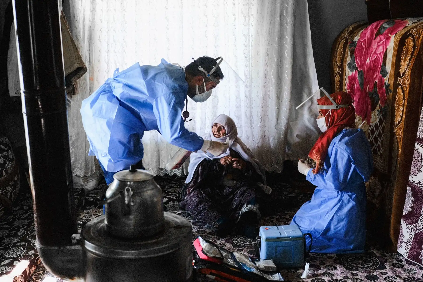 Berfo Arsakay, de 101 años, se prepara para recibir una vacuna CoronaVac por parte del doctor Akay Kaya y la enfermera Yildiz Ayten del equipo de vacunación del hospital público de Bahcesaray, en la aldea de Guneyyamac, en el este de Turquía. Foto: AFP