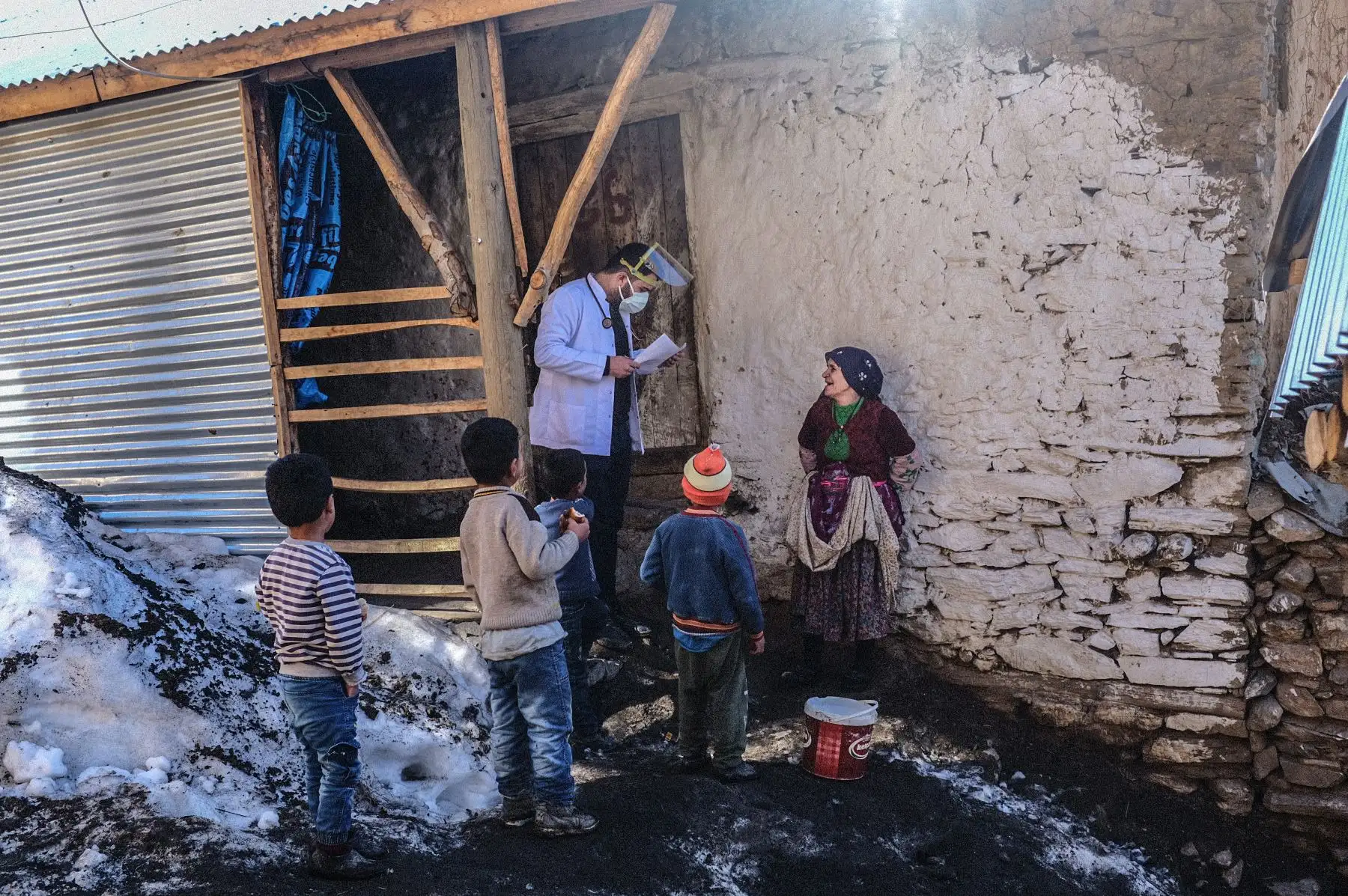 El doctor Akay Kaya del equipo de vacunación del hospital público de Bahcesaray habla con una mujer kurda en la aldea de Guneyyamac en el este de Turquía. Foto: AFP