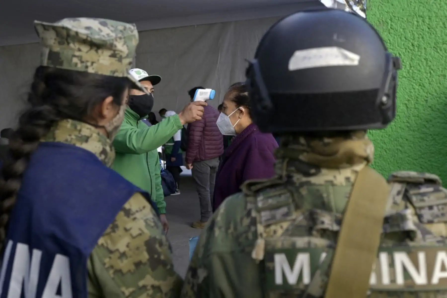 Personal médico toma la temperatura de una mujer mayor de 60 años antes de recibir la primera dosis de la vacuna AstraZeneca contra COVID-19 en el barrio San Pedro Atocpan del corregimiento de Milpa Alta en la Ciudad de México. México comenzó el lunes la segunda fase de su plan de vacunación masiva contra COVID-19 con personas mayores de 60 años. La primera fase, que se centró en el personal médico, duró casi un mes debido a retrasos en la entrega de las dosis.

Foto: AFP