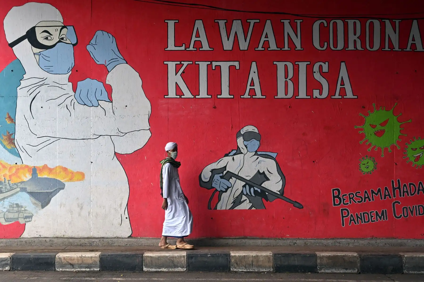 Un musulmán pasa junto a un mural que dice 