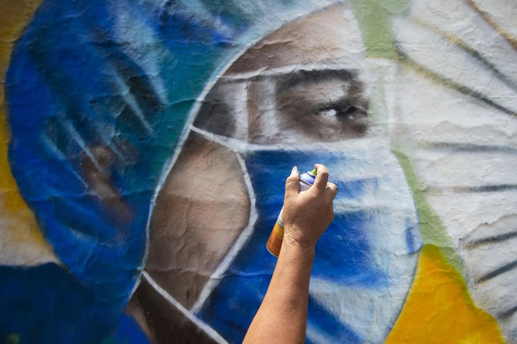 Un artista Mexicano alias Kato, pinta un mural relacionado con el coronavirus, en la Ciudad de México, el 23 de mayo de 2020. Foto: AFP