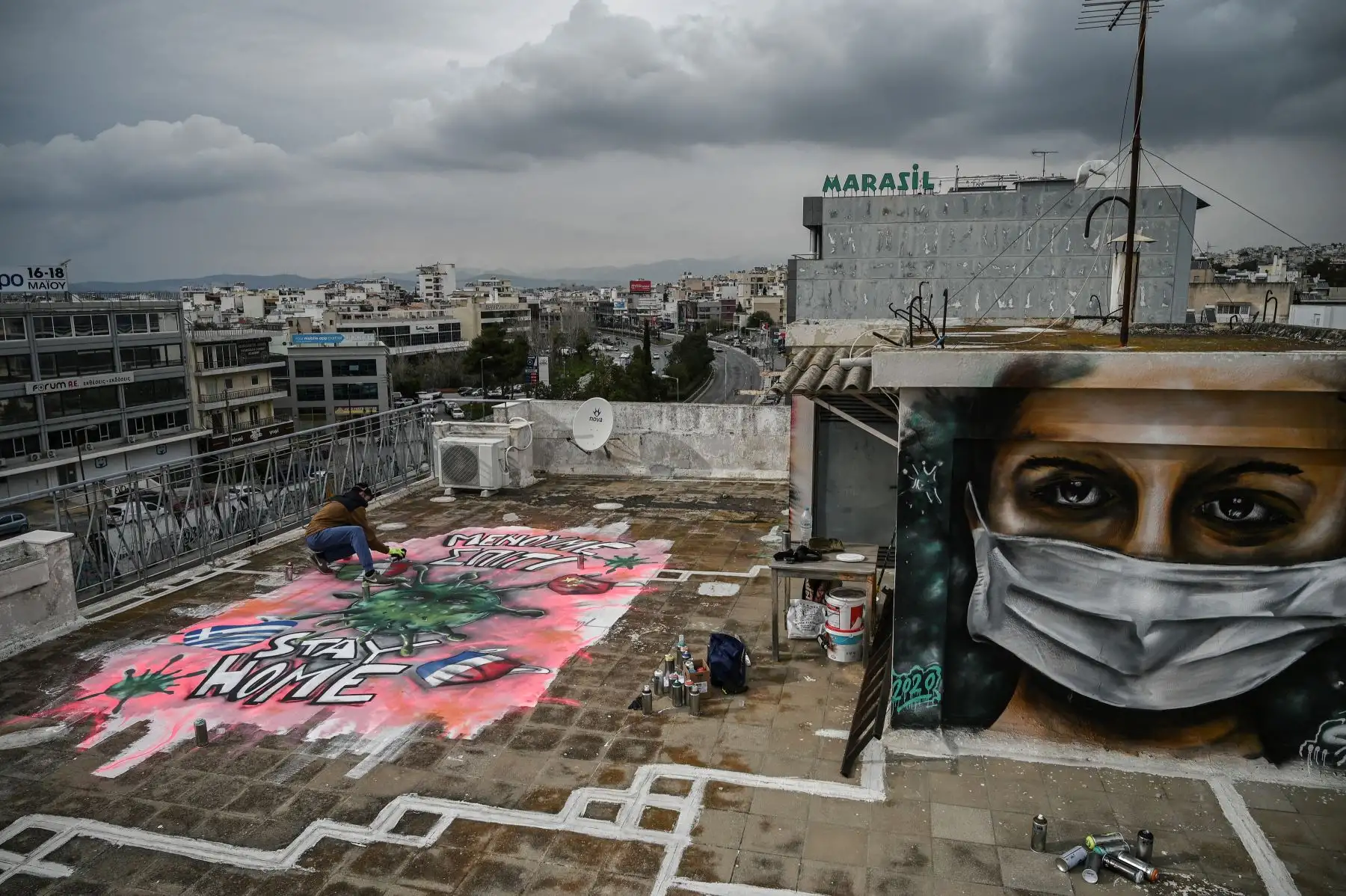 Joven artista de 16 años S.F. pinta un mural sobre la crisis del COVID-19 en la azotea de su edificio en Atenas, Grecia, el 23 de marzo de 2020. Foto: AFP