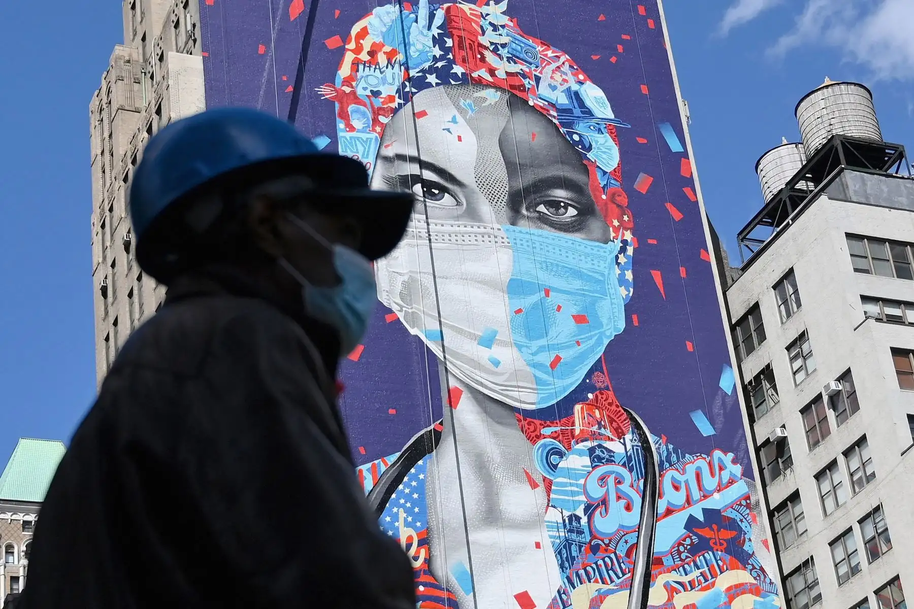 Una persona pasa junto a un mural que rinde homenaje a los médicos que luchan contra el Covid-19, en Nueva York, el 7 de Mayo del 2020. Foto: AFP
