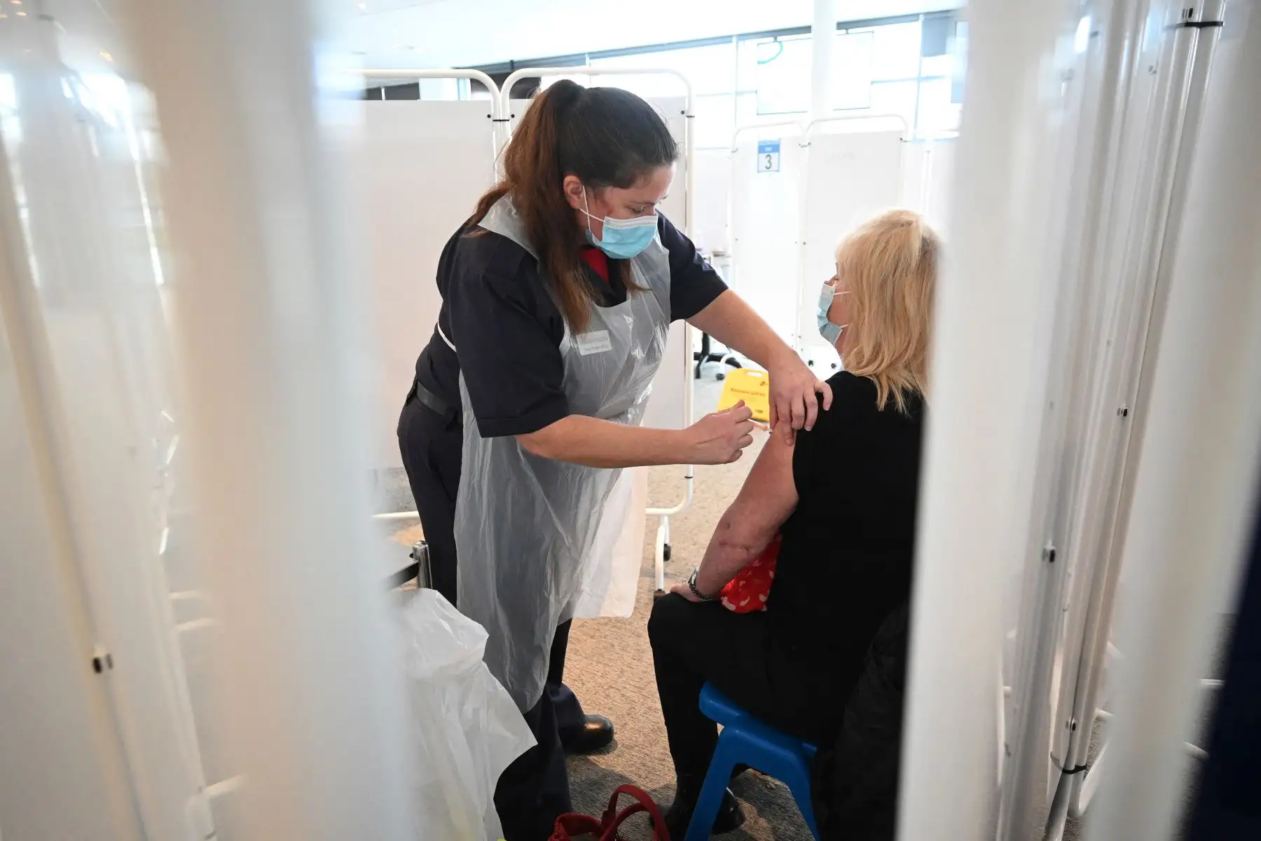 Un médico administra una inyección de la vacuna AstraZeneca Oxford Covid-19 a un paciente en el centro de vacunación establecido en el hipódromo de Chester, al noroeste de Inglaterra. Foto: AFP