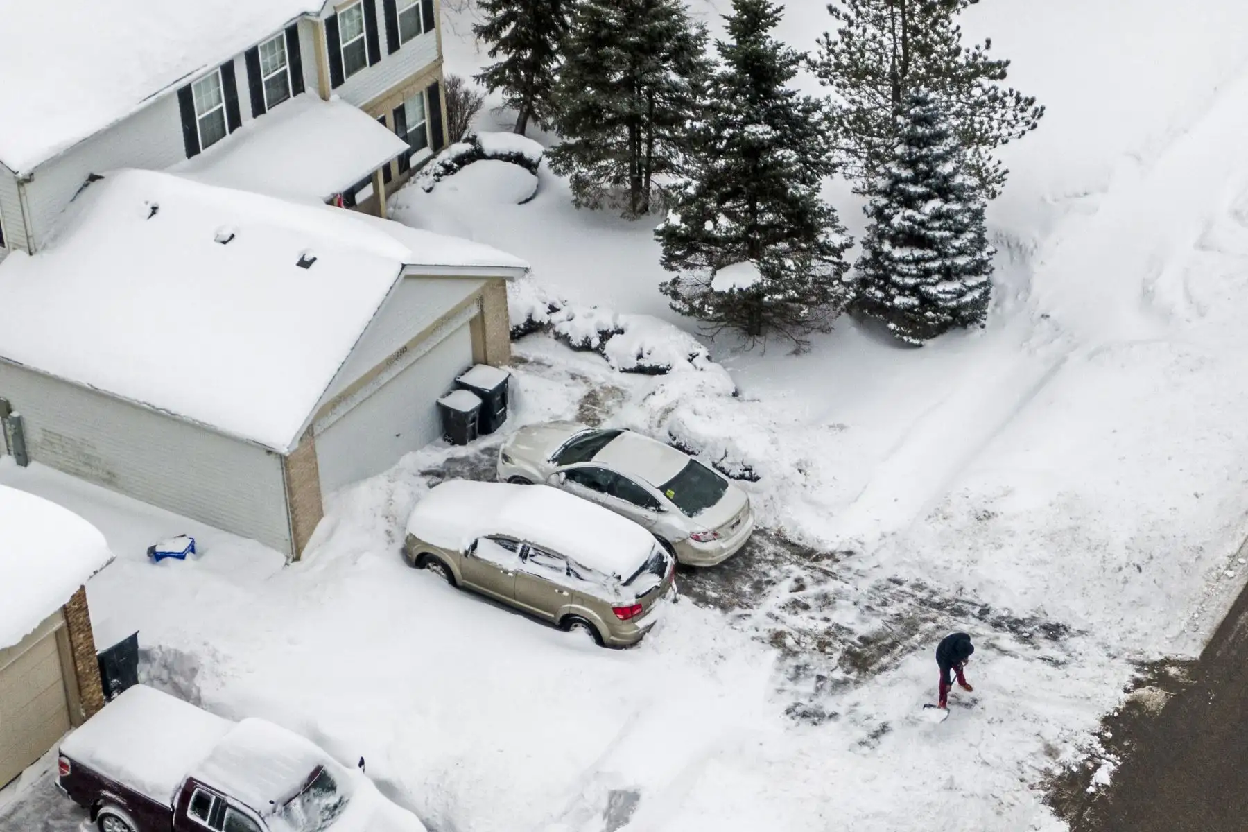Una foto aérea realizada con un dron muestra a un hombre excavando después que una nevada cubriera los exteriores de su vivienda en Illinois, Estados Unidos. Foto: EFE