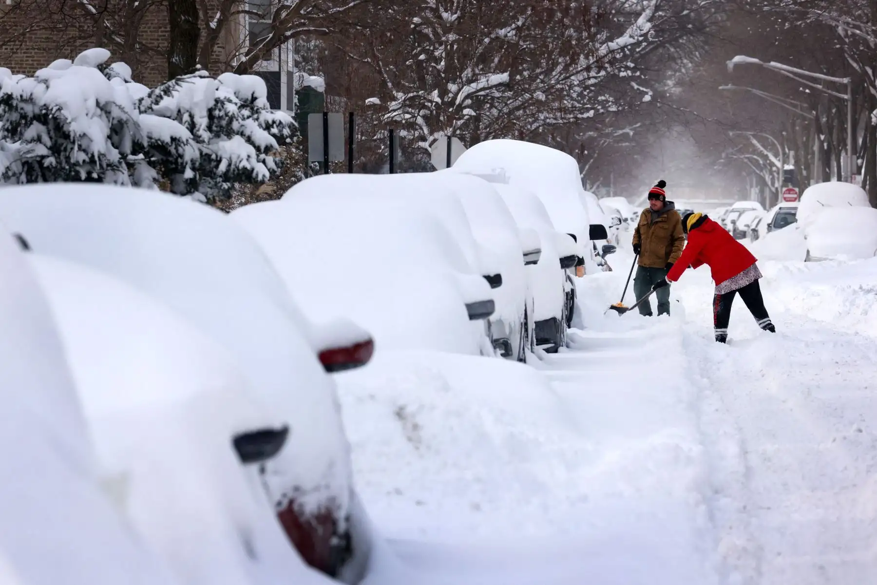 La gente trabaja para excavar su automóvil a lo largo de una calle residencial en Chicago, Illinois, en los Estados Unidos. Foto: AFP