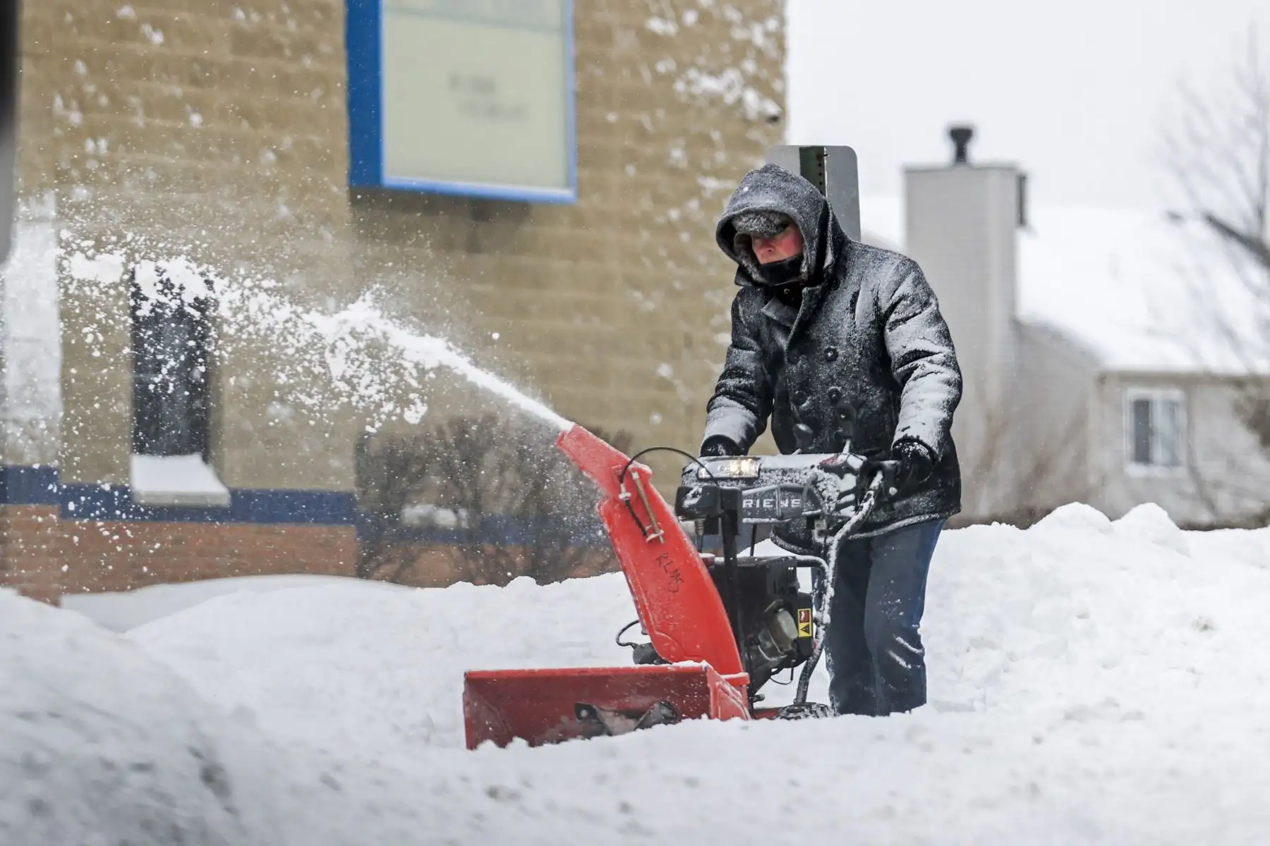 Un hombre usa un soplador de nieve para despejar una acera después de que una nevada nocturna la dejara cubierta en su totalidad. Foto: EFE