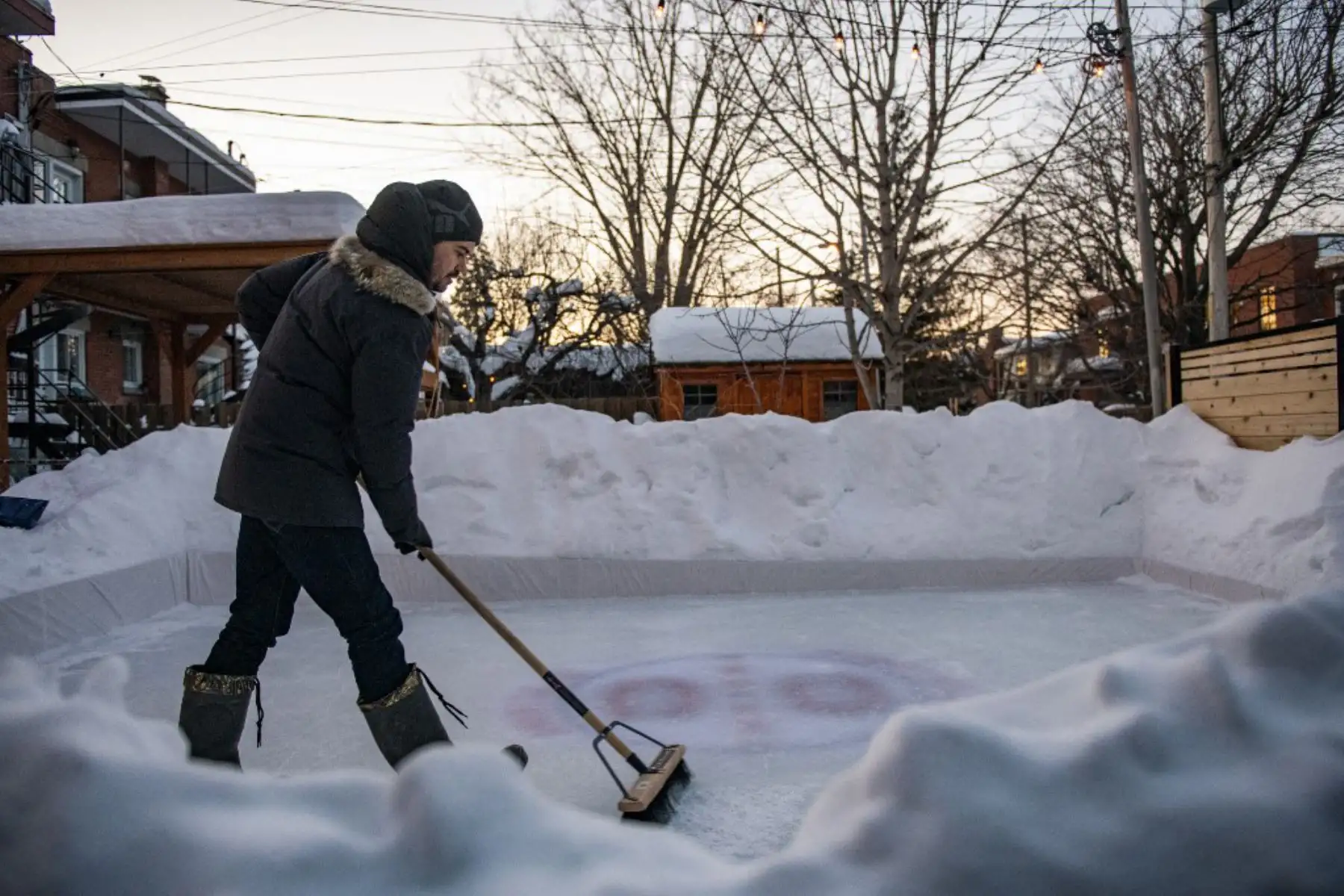 Felix Rheaume trabajando en la pista de hielo en su patio trasero en Montreal, Quebec. Más canadienses que nunca, ya que las autoridades de salud pública han restringido las reuniones públicas y otras actividades sociales, este año están abrazando a una antigua tradición invernal en este país: la pista de patinaje sobre hielo que les permite patinar y jugar al hockey sobre hielo, el pasatiempo nacional de Canadá, y al mismo tiempo evitar contactos, más allá de sus familiares y amigos inmediatos, que podrían