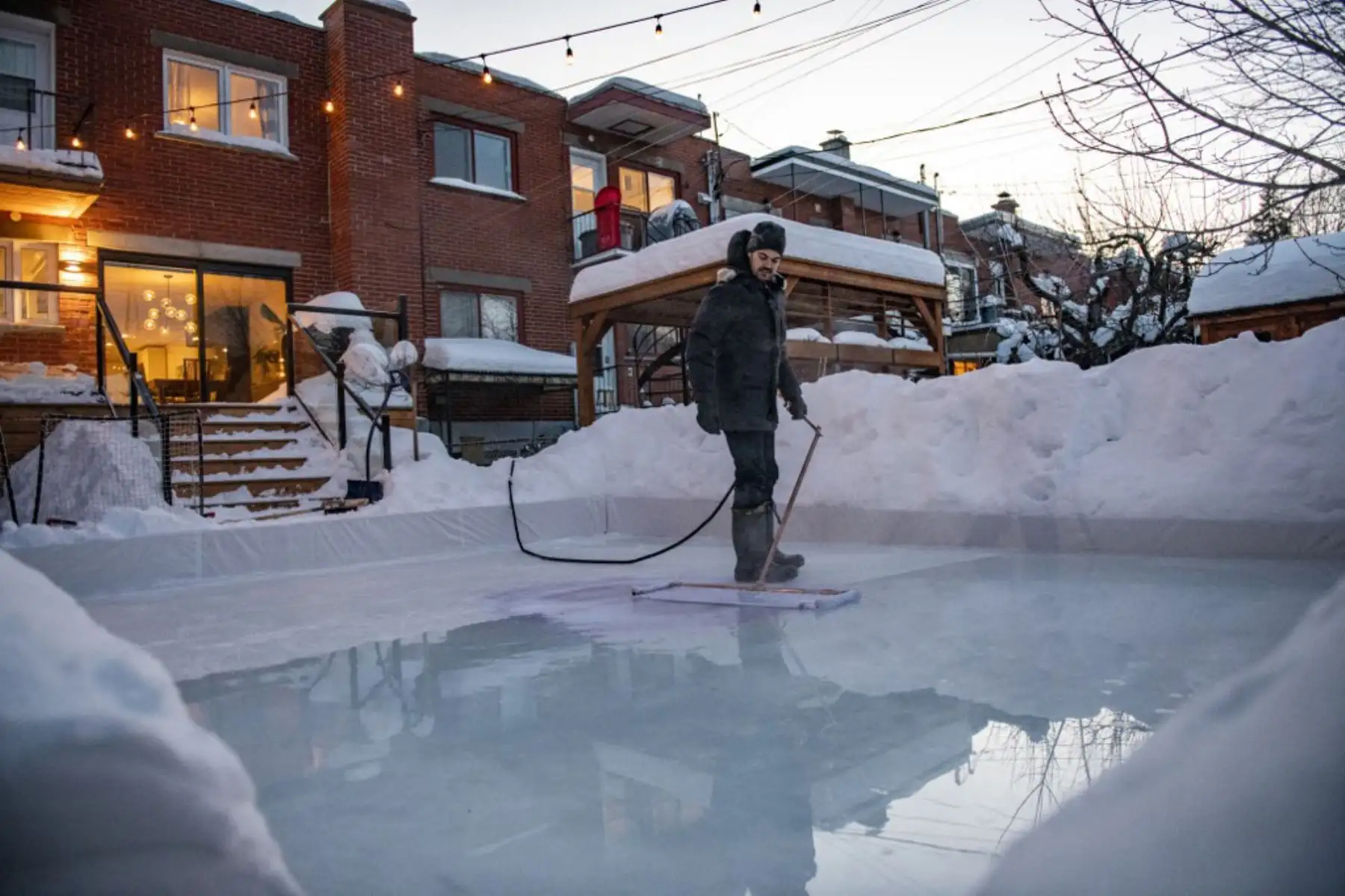 Felix Rheaume realiza el mantenimiento de la pista de hielo en su patio trasero en Montreal, Quebec. Más canadienses que nunca, ya que las autoridades de salud pública han restringido las reuniones públicas y otras actividades sociales, este año están abrazando a una antigua tradición invernal en este país: la pista de patinaje sobre hielo que les permite patinar y jugar al hockey sobre hielo, el pasatiempo nacional de Canadá, y al mismo tiempo evitar contactos, más allá de sus familiares y amigos inmediato