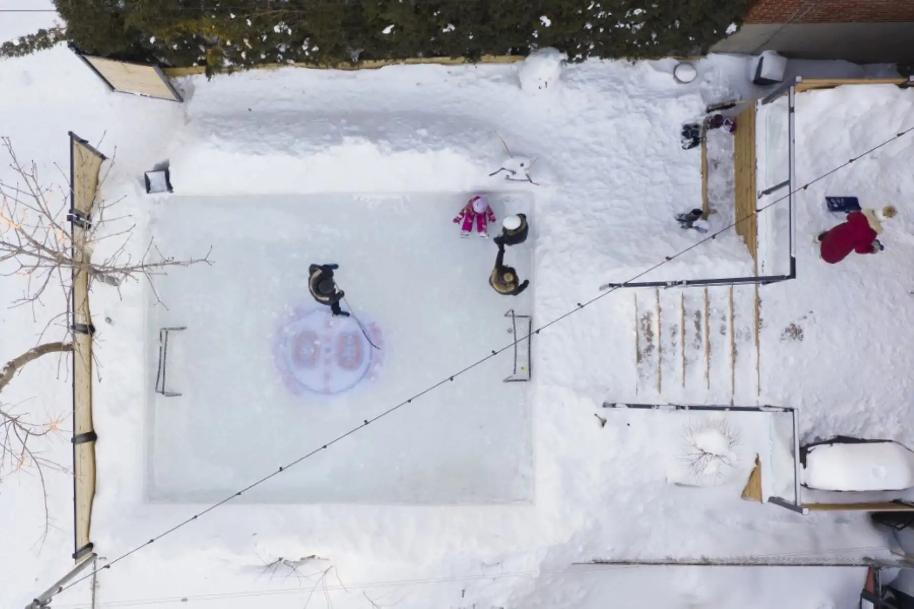 Vista aérea de la pista de hielo en un patio trasero en Montreal, Quebec. Más canadienses que nunca, ya que las autoridades de salud pública han restringido las reuniones públicas y otras actividades sociales, este año están abrazando a una antigua tradición invernal en este país: la pista de patinaje sobre hielo que les permite patinar y jugar al hockey sobre hielo, el pasatiempo nacional de Canadá, y al mismo tiempo evitar contactos, más allá de sus familiares y amigos inmediatos, que podrían propagar la