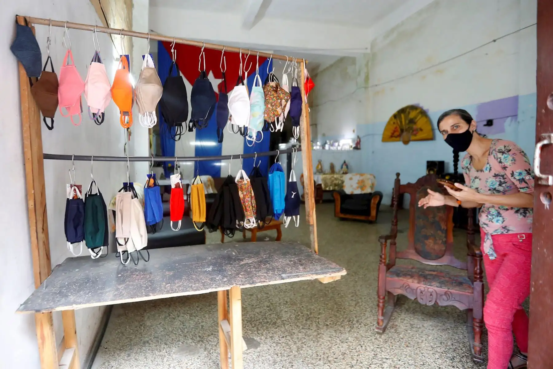 Una mujer vende hoy mascarillas en la puerta de su casa, en La Habana (Cuba). A pesar del avance de la pandemia en Cuba, donde se registraron 923 casos este jueves, la mitad de ellos en La Habana, los habitantes de la capital cubana continúan con su laborioso día a día. EFE/Yander Zamora