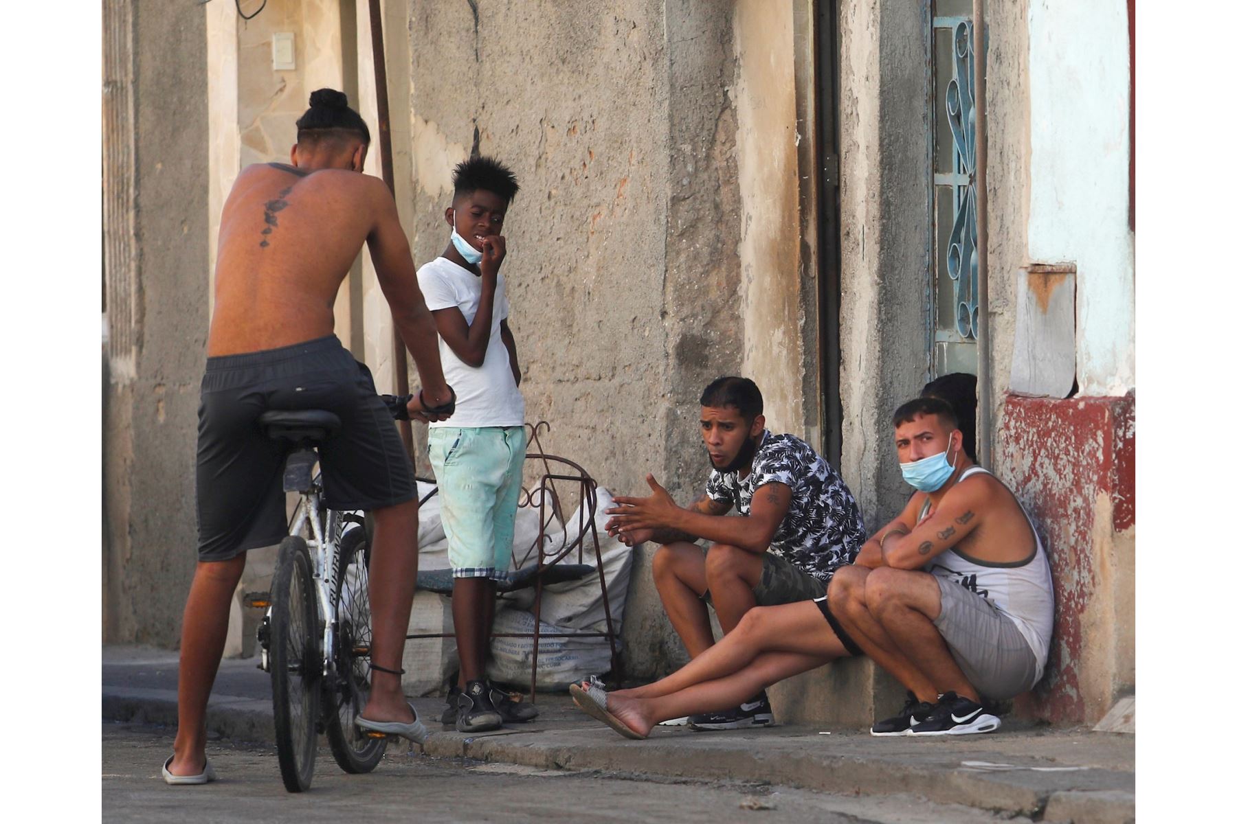 Varias personas conversan hoy en la puerta de una casa, en La Habana (Cuba). A pesar del avance de la pandemia en Cuba, donde se registraron 923 casos este jueves, la mitad de ellos en La Habana, los habitantes de la capital cubana continúan con su laborioso día a día. EFE/Yander Zamora