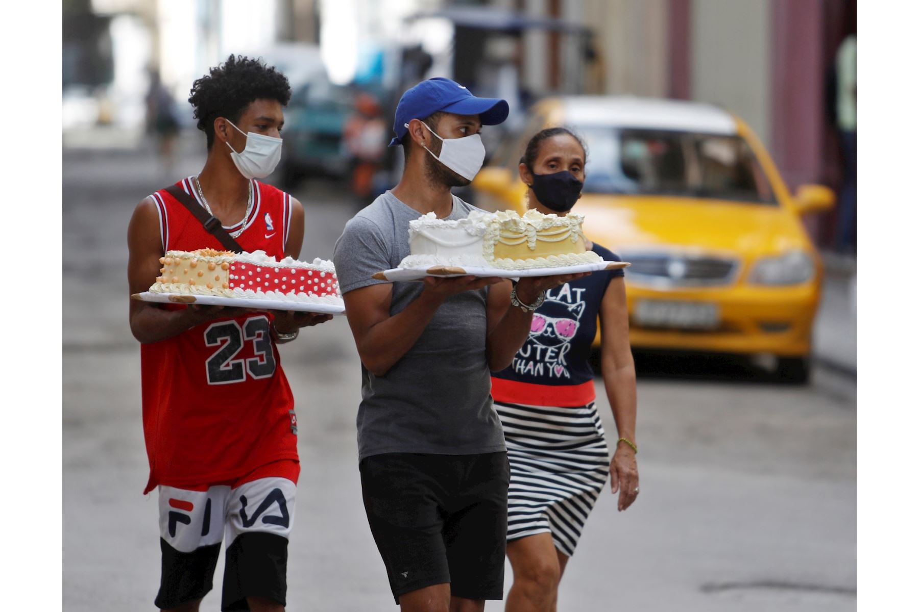 Varias personas cargan hoy unos pasteles en La Habana (Cuba). A pesar del avance de la pandemia en Cuba, donde se registraron 923 casos este jueves, la mitad de ellos en La Habana, los habitantes de la capital cubana continúan con su laborioso día a día. EFE/Yander Zamora