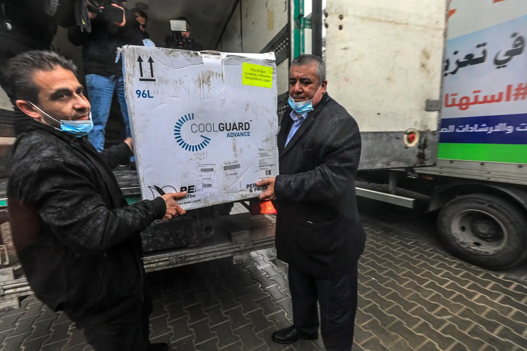 Los empleados de salud palestinos reciben las vacunas Covid-19 después de que un envío cruzara la frontera de Karm Abu Salem desde el Ministerio de Salud en Ramallah, en la ciudad de Gaza. El primer envío de 1.000 vacunas contra el coronavirus Sputnik V enviadas por la autoridad palestina entraron en la Franja de Gaza después de que fuera bloqueada previamente el 15 de febrero en un puesto de control israelí. 
Foto: EFE