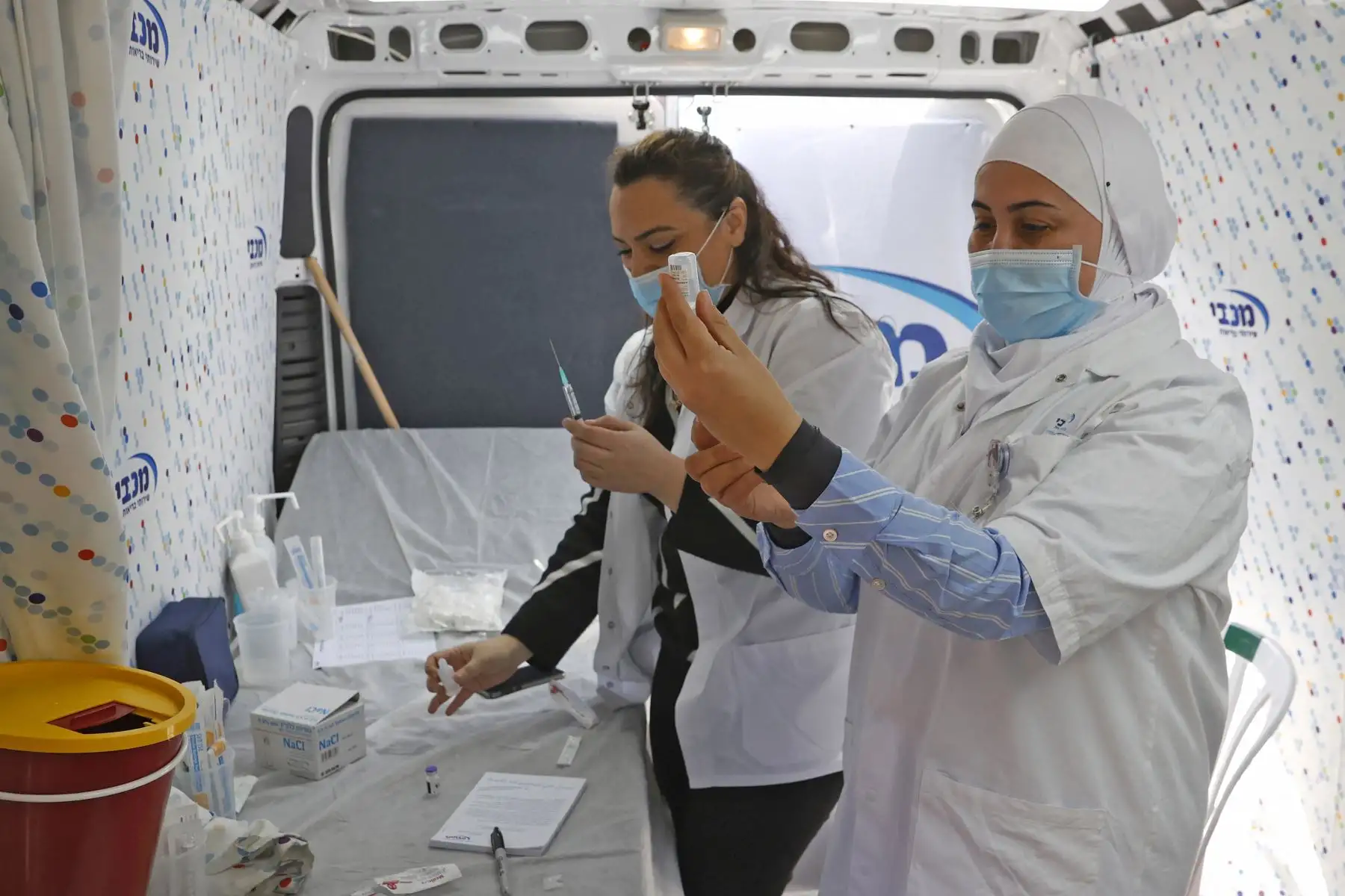 Los trabajadores de la salud de Maccabi Healthcare Services se preparan para administrar dosis de la vacuna contra el coronavirus Pfizer-BioNtech dentro de una camioneta en la ciudad costera israelí de Tel Aviv-Jaffa.
Foto:AFP.