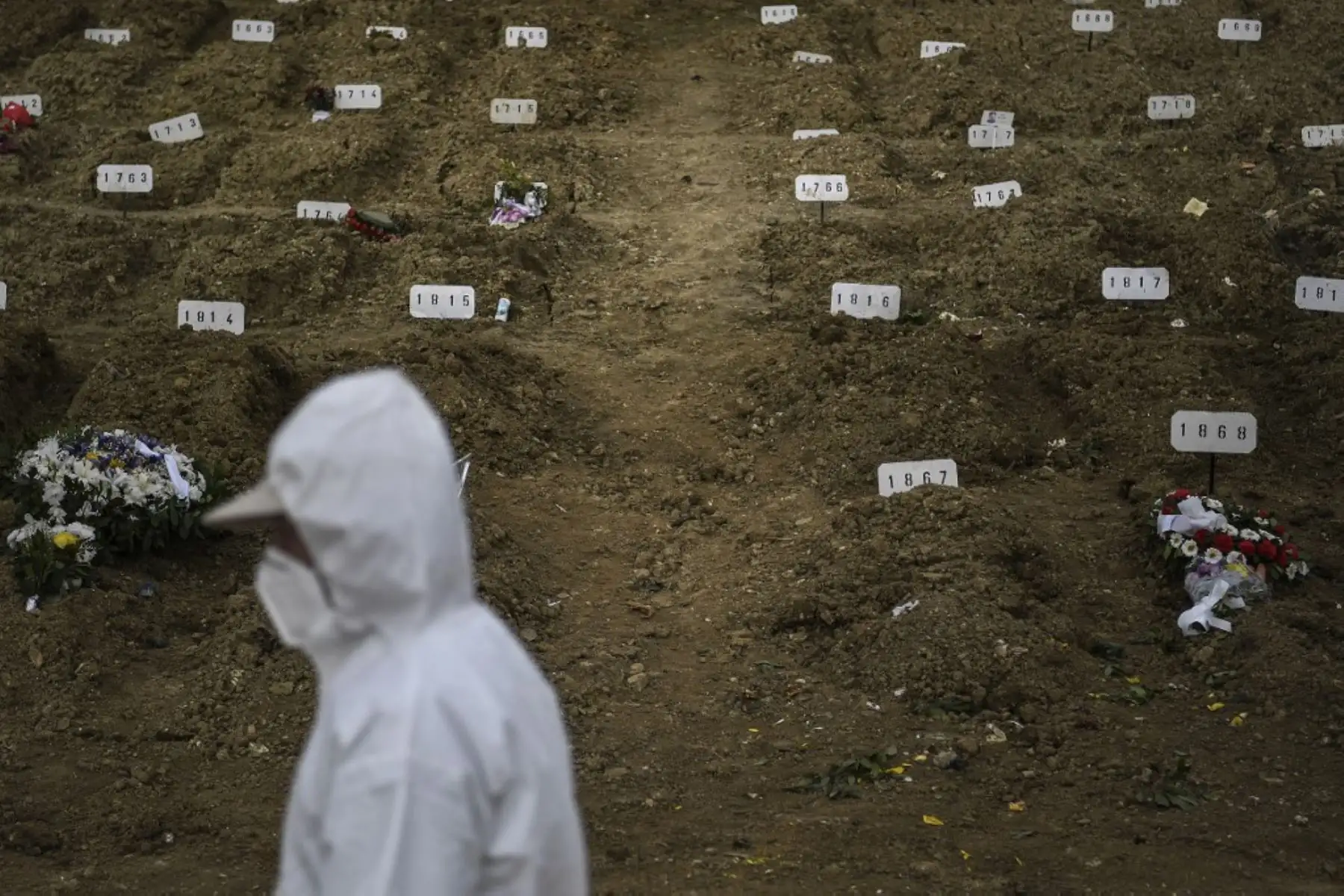 Un sepulturero con traje protector pasa junto a las tumbas durante el entierro de una víctima de Covid-19 en el cementerio Alto de Sao Joao en Lisboa. En enero, Portugal sufrió la peor tasa de infecciones por coronavirus en el mundo y desde el 15 de enero el país ha estado bajo un bloqueo general.

Foto: AFP