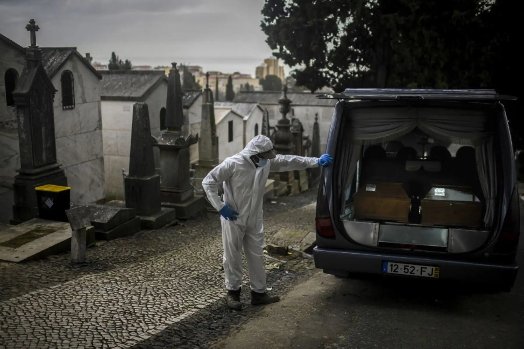 Un sepulturero con traje protector se encuentra junto a un coche fúnebre que transporta los ataúdes de dos víctimas del Covid-19 en el cementerio Alto de Sao Joao en Lisboa. En enero, Portugal sufrió la peor tasa de infecciones por coronavirus en el mundo y desde el 15 de enero el país ha estado bajo un bloqueo general.

Foto: AFP