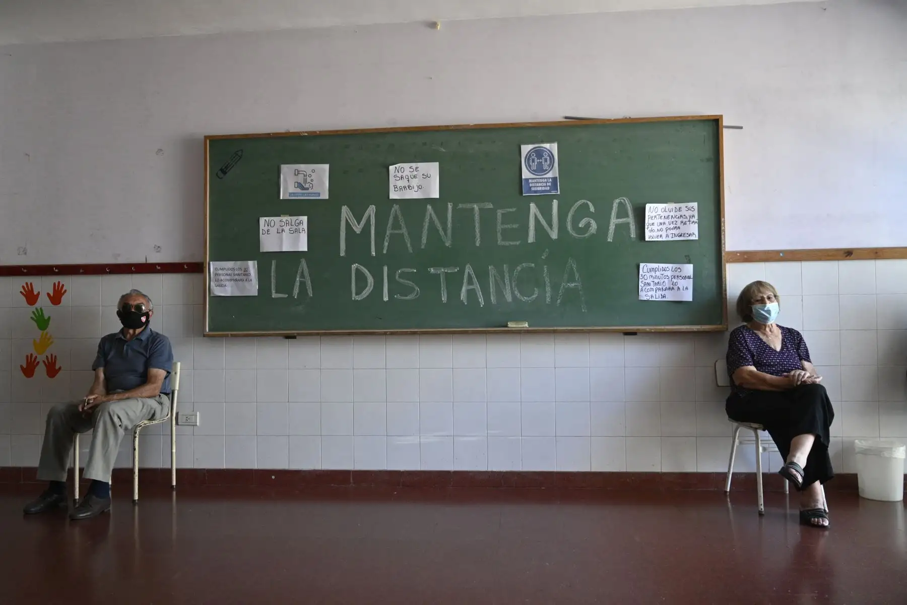 Ancianos esperan para salir después de recibir una dosis de la vacuna Sputnik V contra COVID-19, en un centro de vacunación temporal de una escuela pública en Ezeiza, en las afueras de Buenos Aires. Foto: AFP
