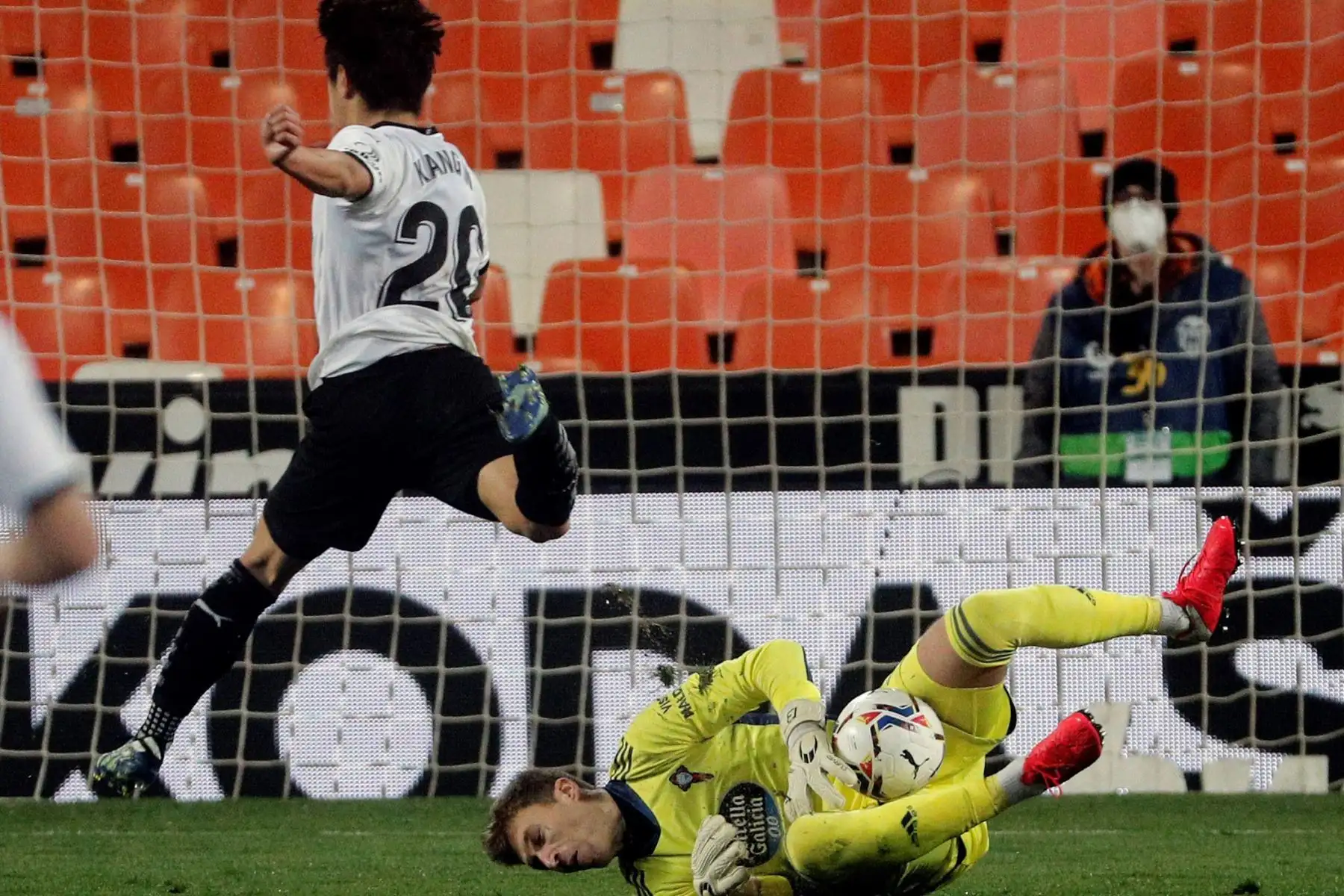 El portero del Celta, Rubén Blanco, para el balón ante el jugador del Valencia, Lee Kang-in, durante el partido de La Liga Santander de la jornada 24 que disputan en el estadio de Mestalla. 
Foto: EFE